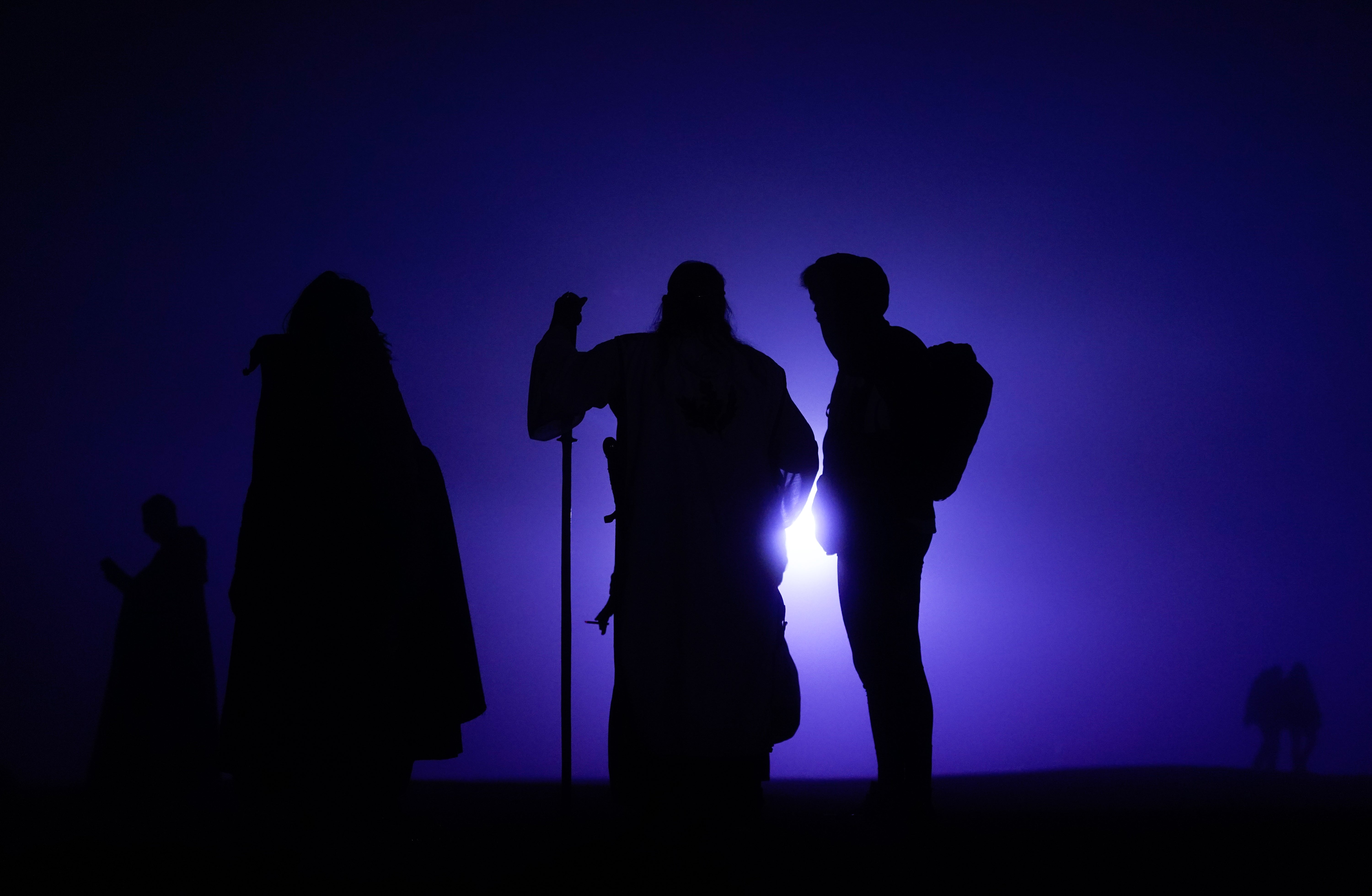 Crowds gather at before dawn during the Summer Solstice at Stonehenge in Wiltshire (Andrew Matthews/PA)