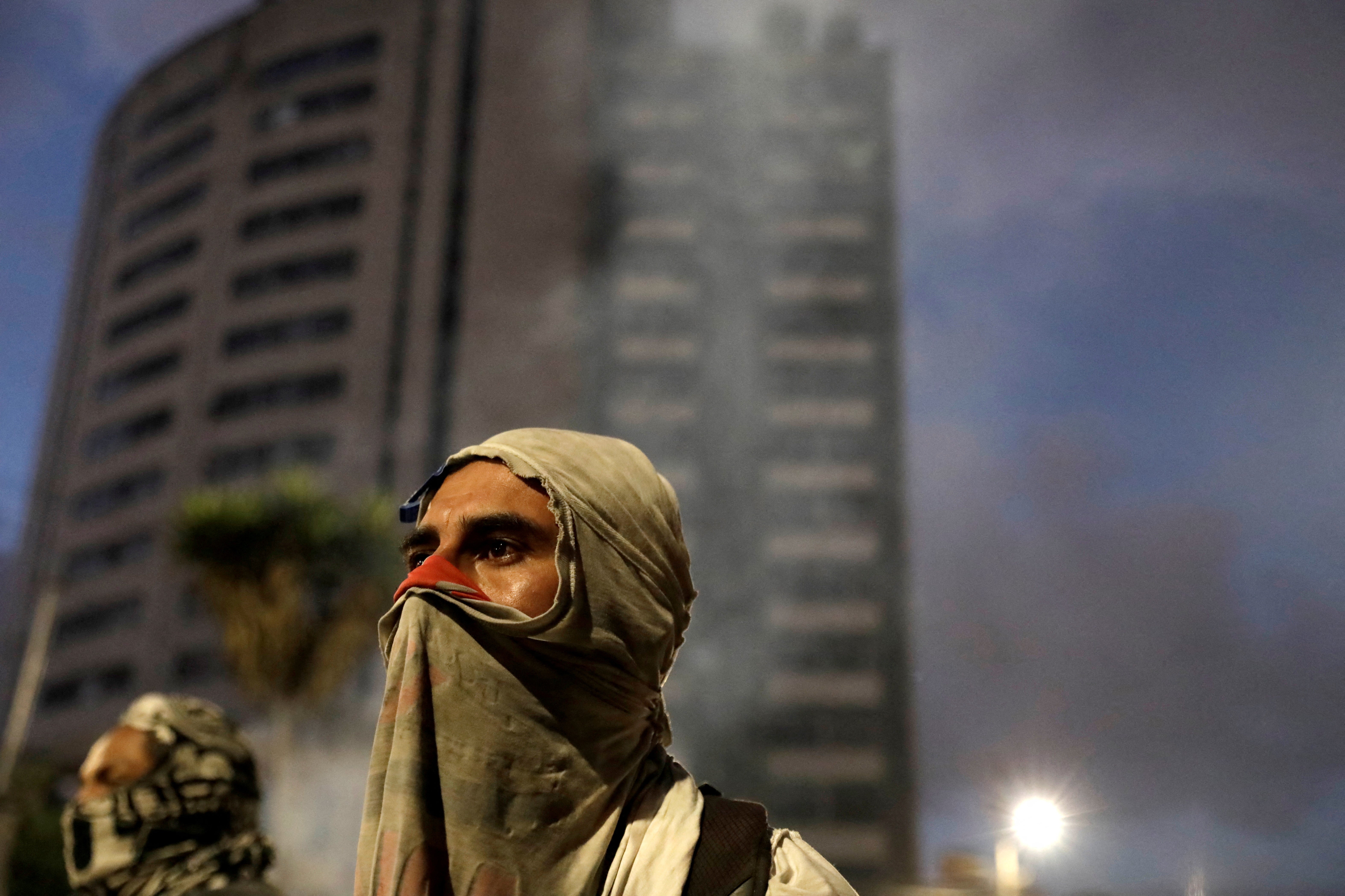 Protesters gather near a burning road blockade