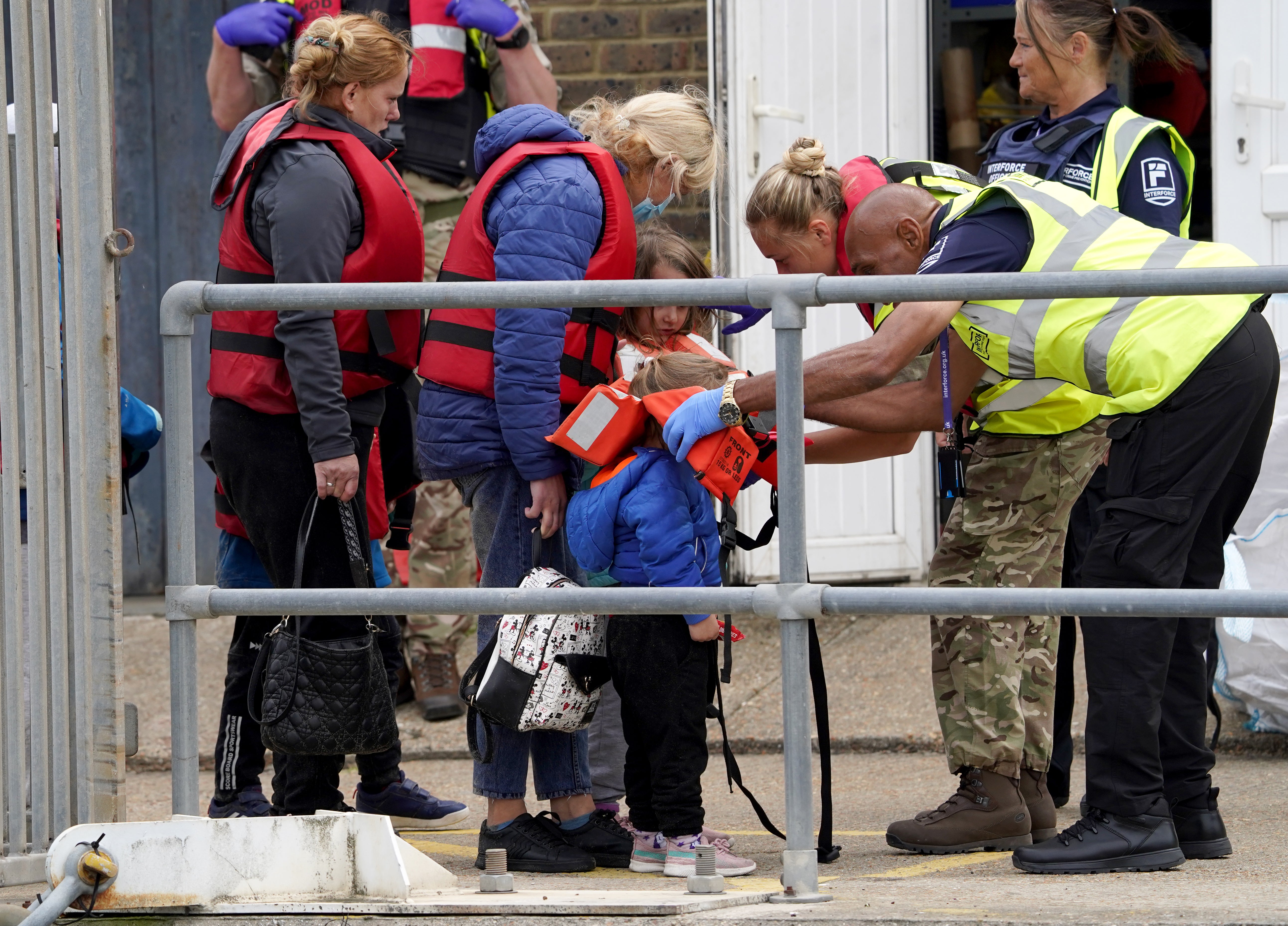 A young child is helped amongst a group of people thought to be migrants as they are brought in to Dover, Kent (Gareth Fuller/PA)