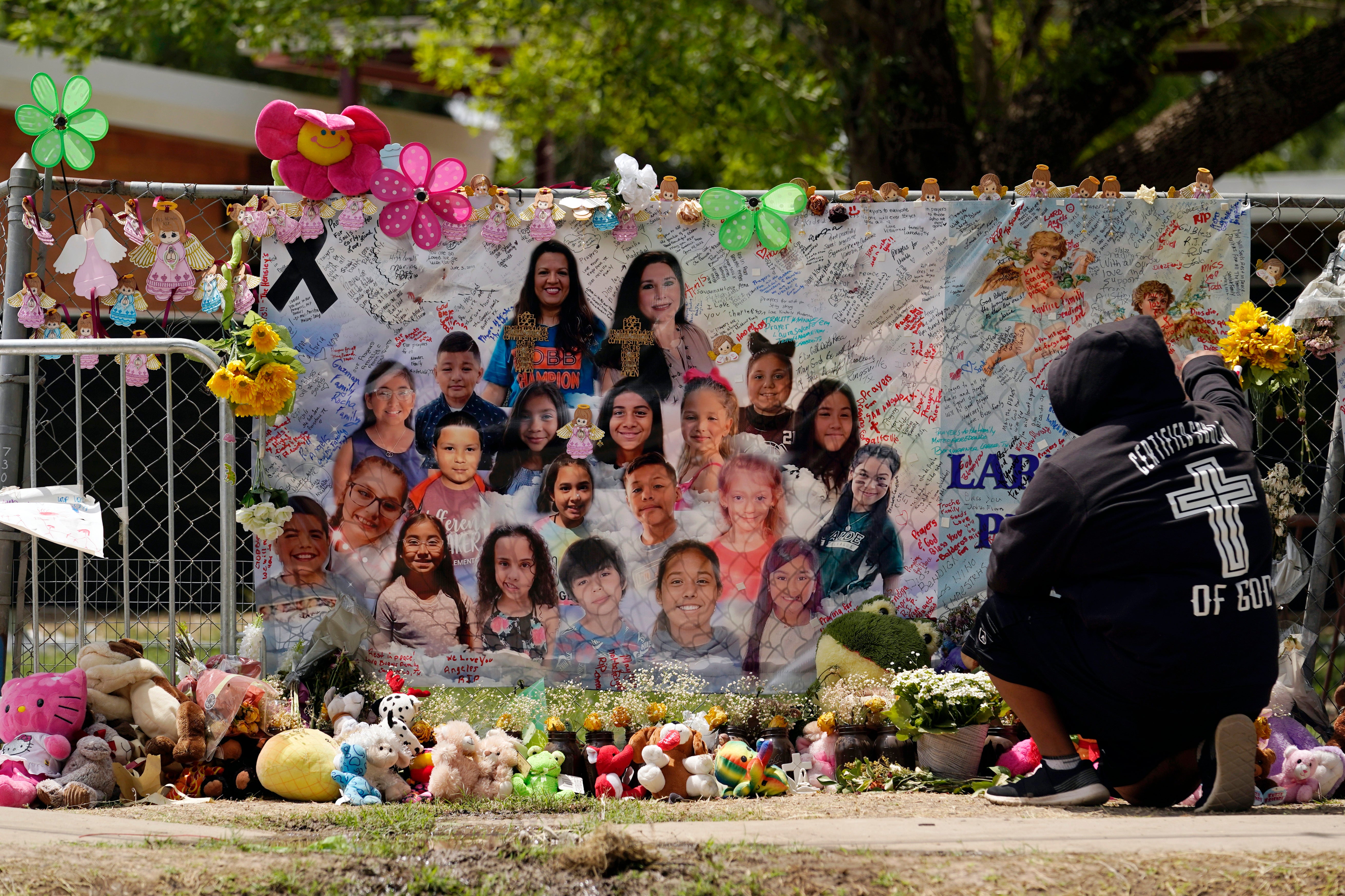 A mourner stops to pay his respects at a memorial at Robb Elementary School