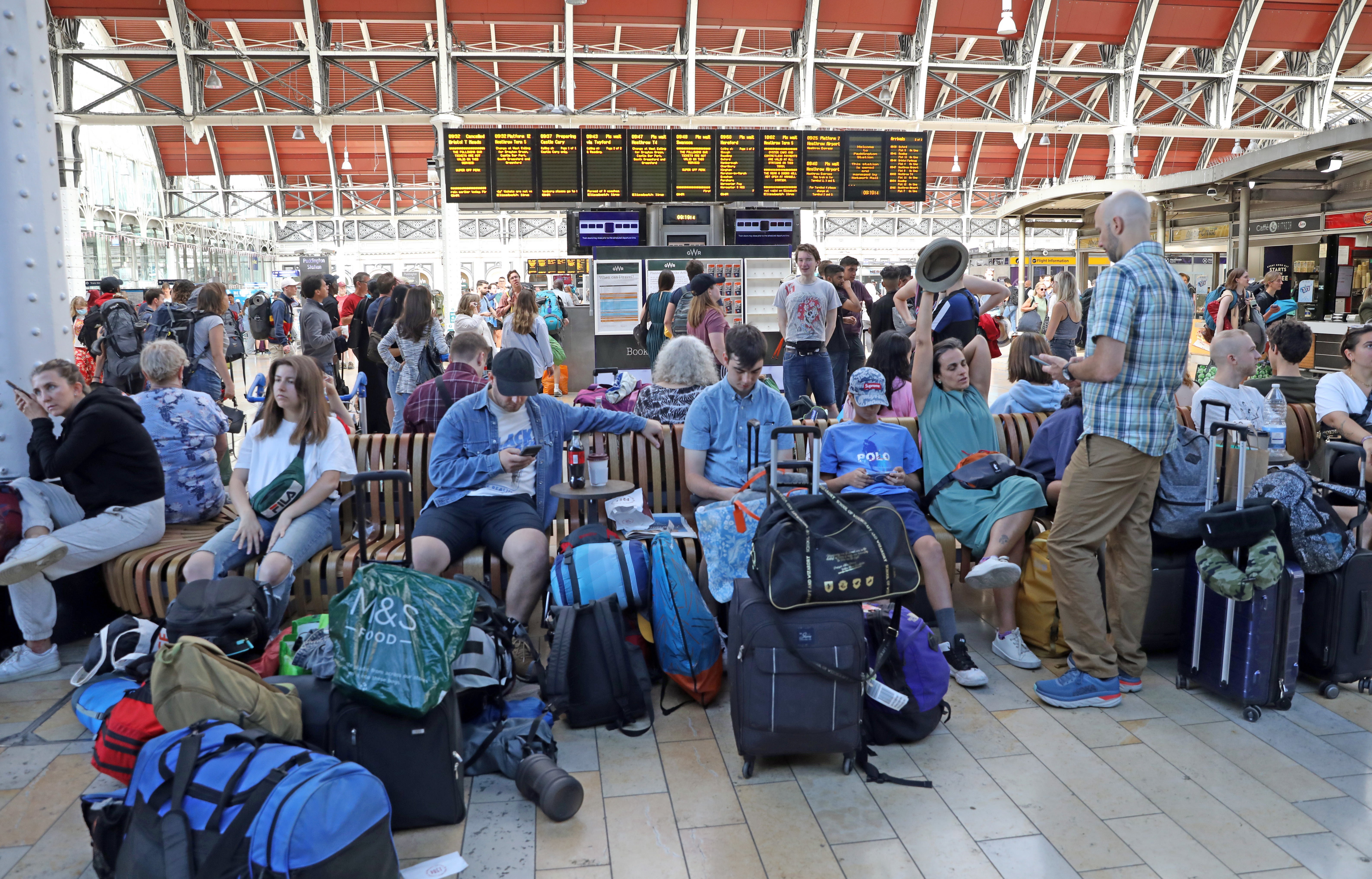 Passengers bound for the Glastonbury Festival wait at Paddington station in London (Ashlee Ruggels/PA)