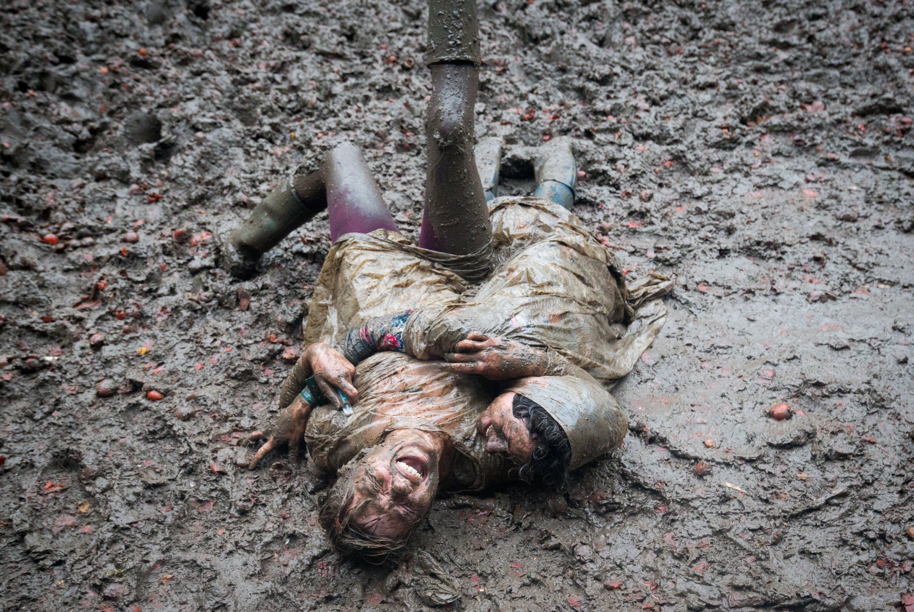 Two festival revellers roll in the mud after they took part in a tomato fight in 2016