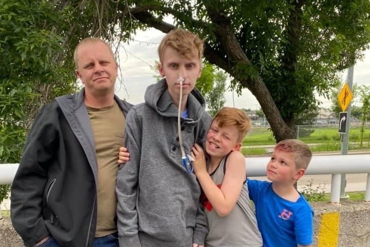 Eric, second left, poses with his father, Wade Coulam, left, and his two younger brothers