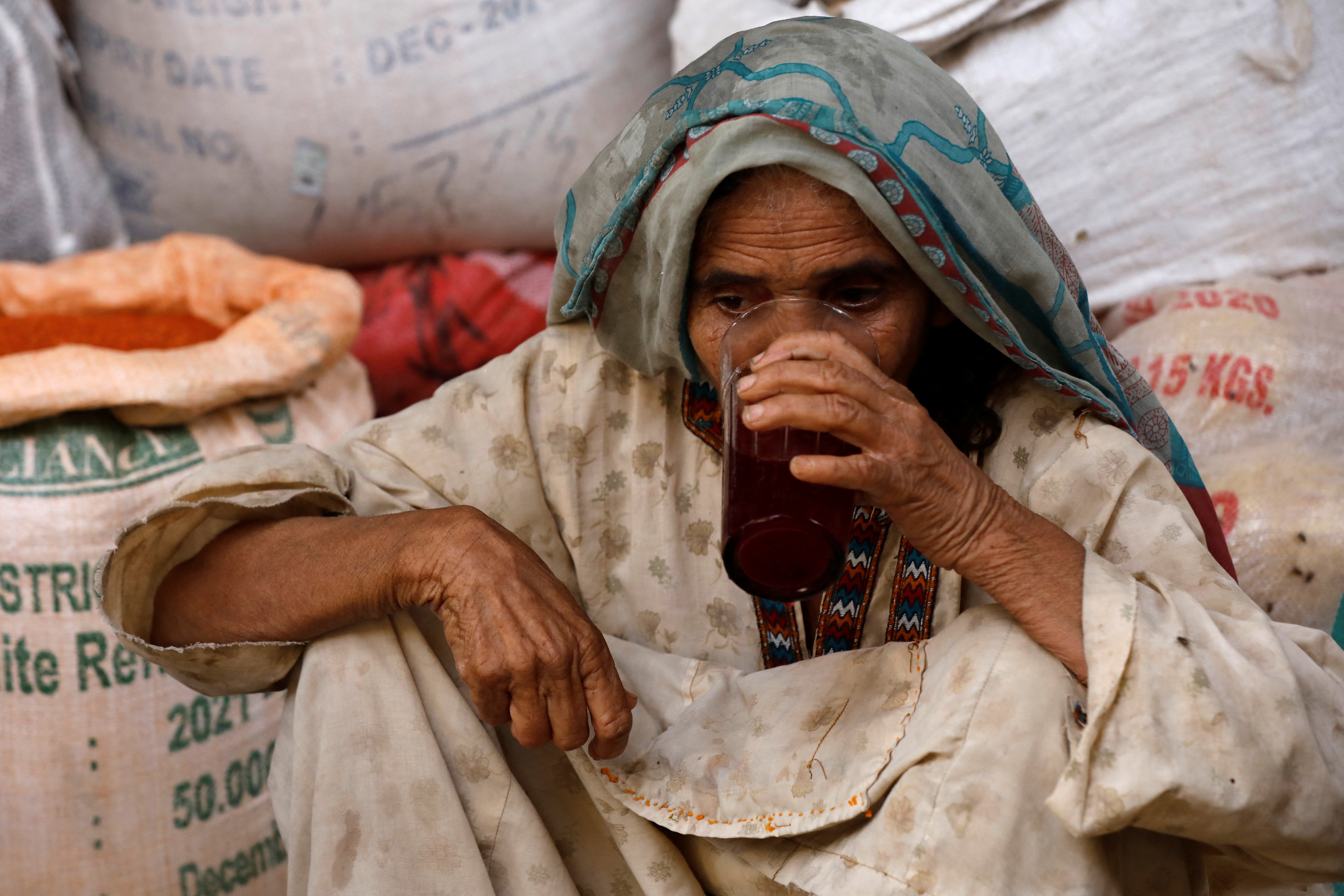 A woman drinks a plum and tamarind drink to cool off