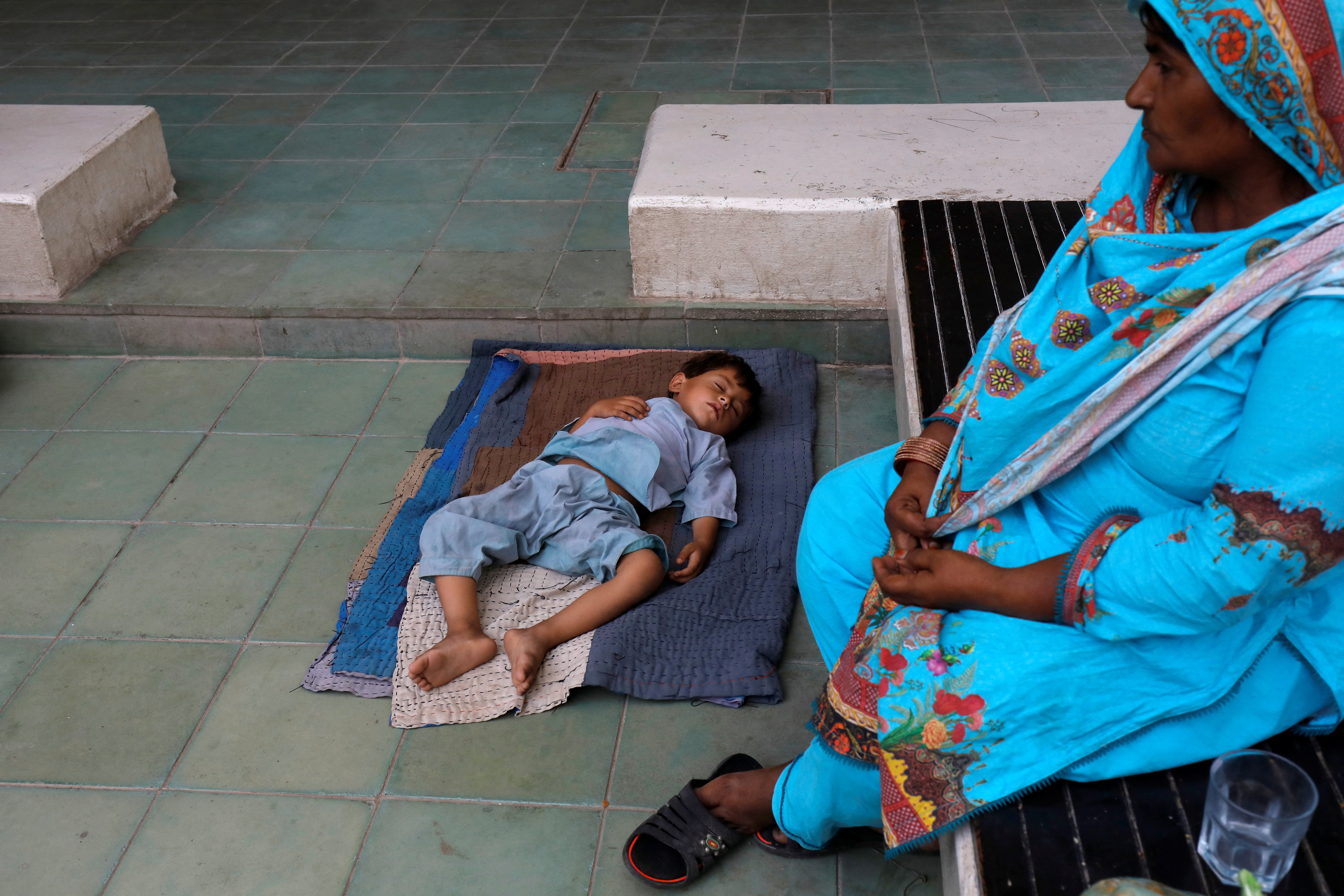 A grandmother visits her grandson while he sleeps