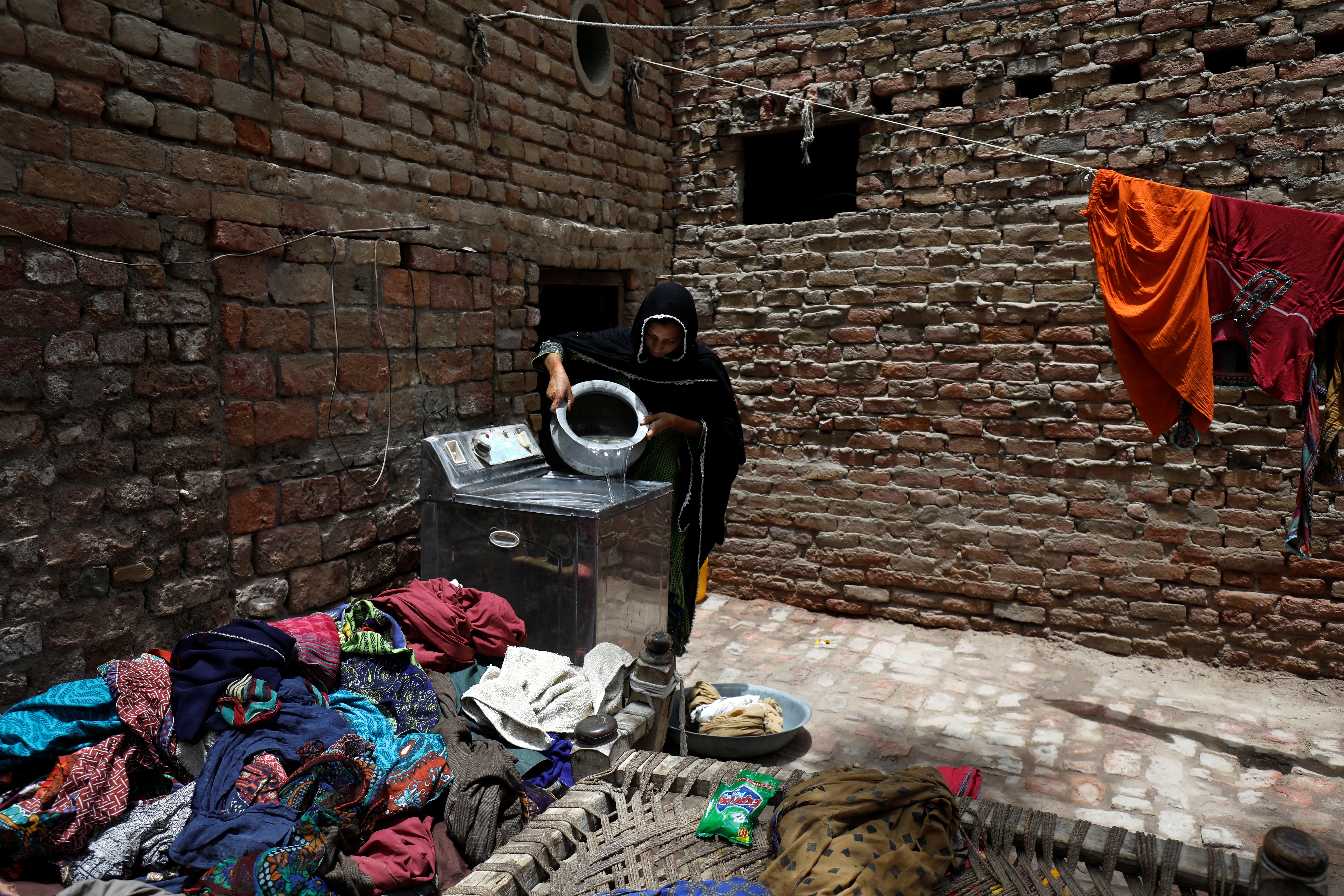 Zahida, 16, washes clothes during a heatwave