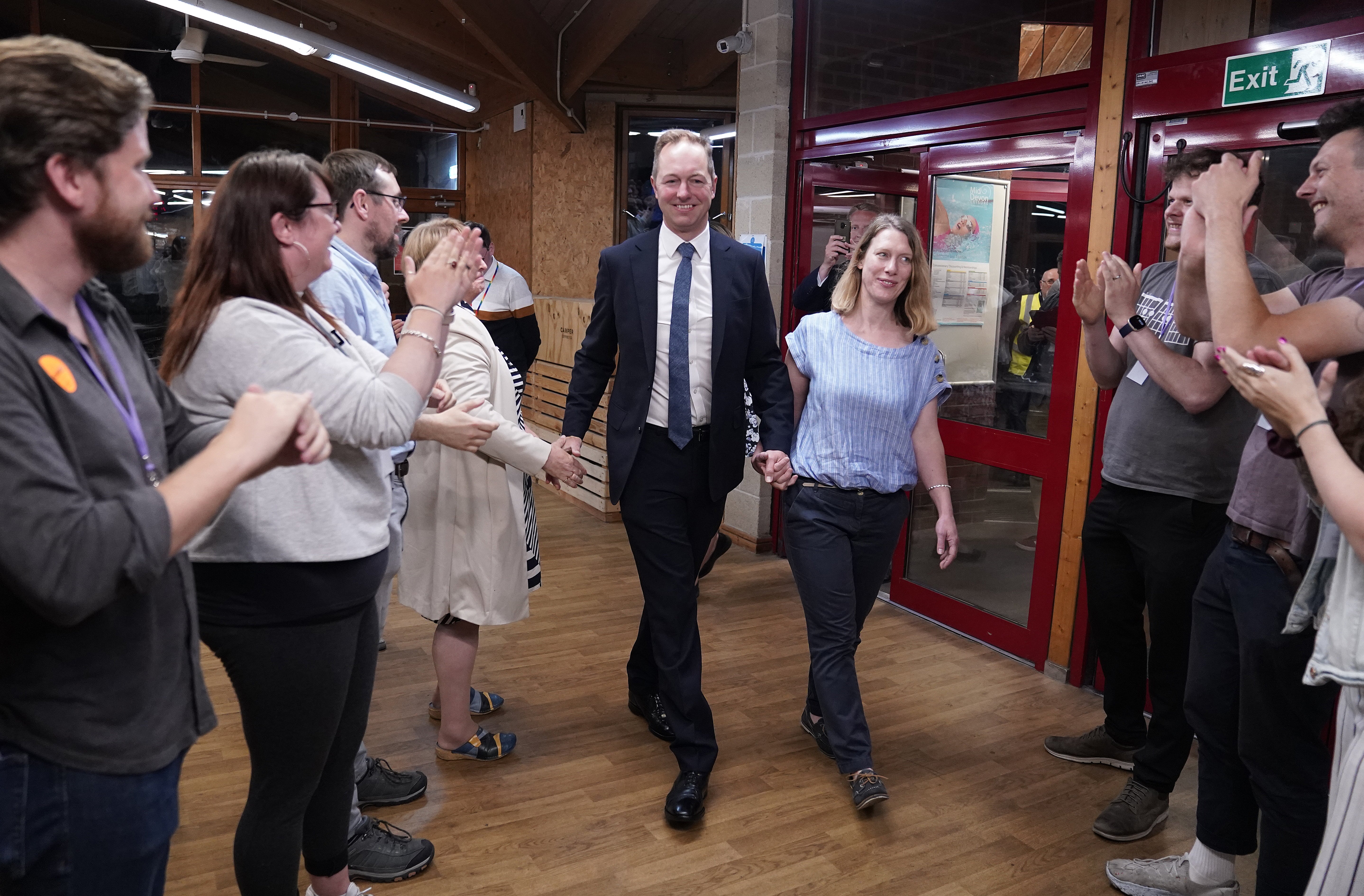 The Liberal Democrats’ by-election candidate Richard Foord and his wife Kate are greeted by supporters as they arrive at the Lords Meadow Leisure Centre, in Crediton, Devon (PA)