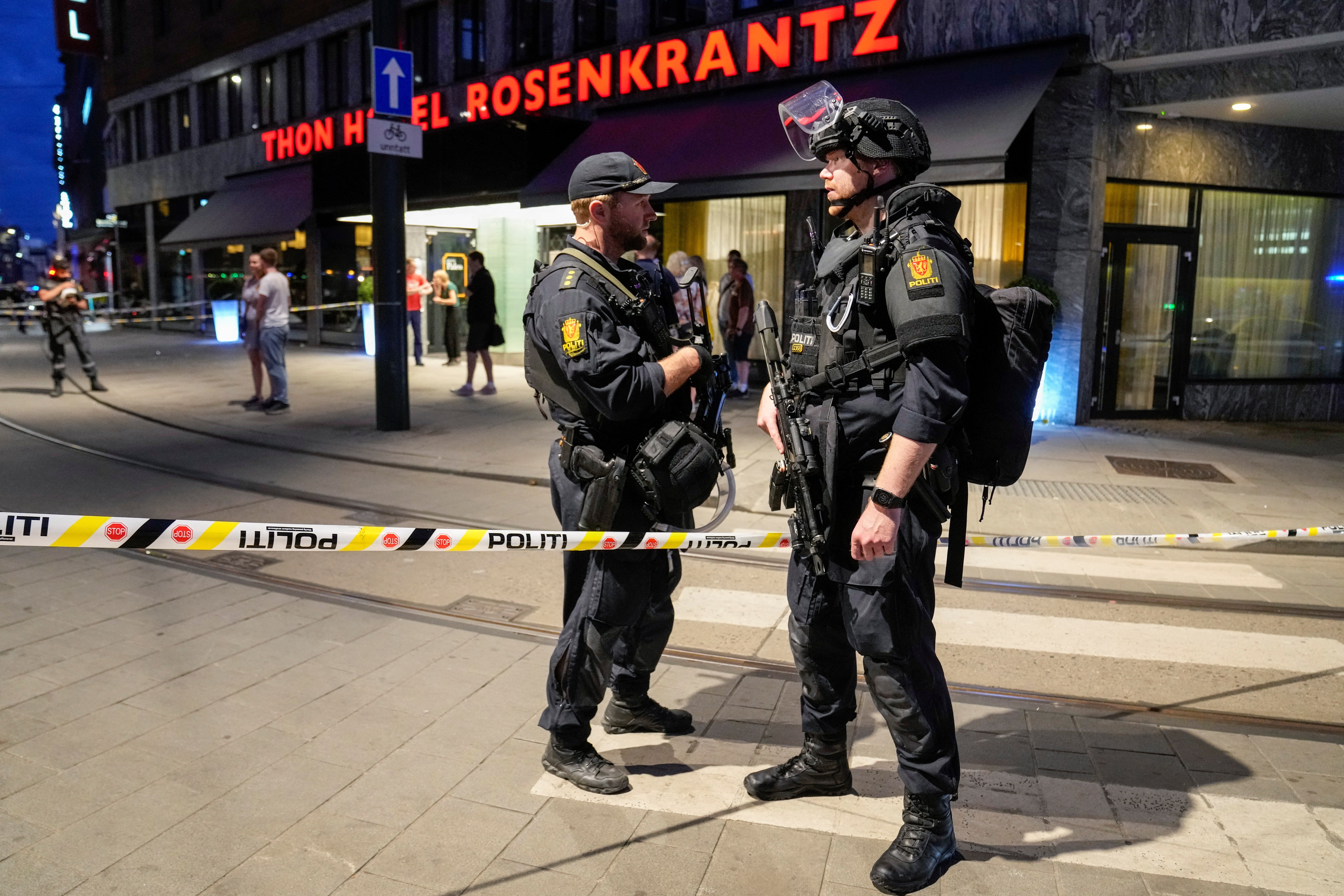 Security forces stand at the site where several people were injured during a shooting outside the London pub in central Oslo, Norway