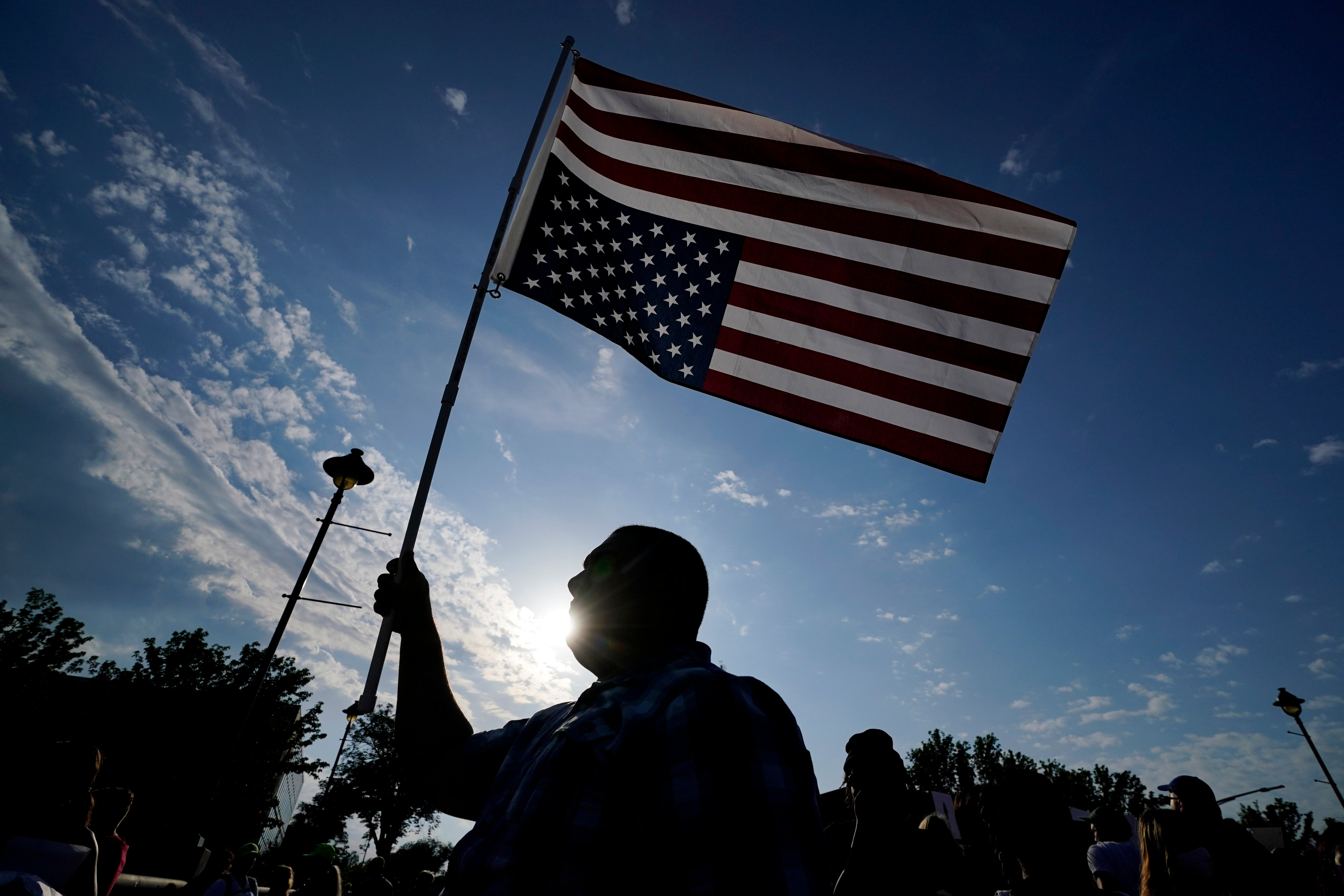 Abortion-rights protester Ryan Maher carries a flag during a march to the Iowa governor's mansion on Friday