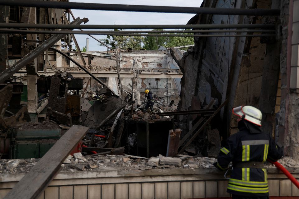 Rescuers work at a site of a facility of the Darnytsia Car Repair Plant