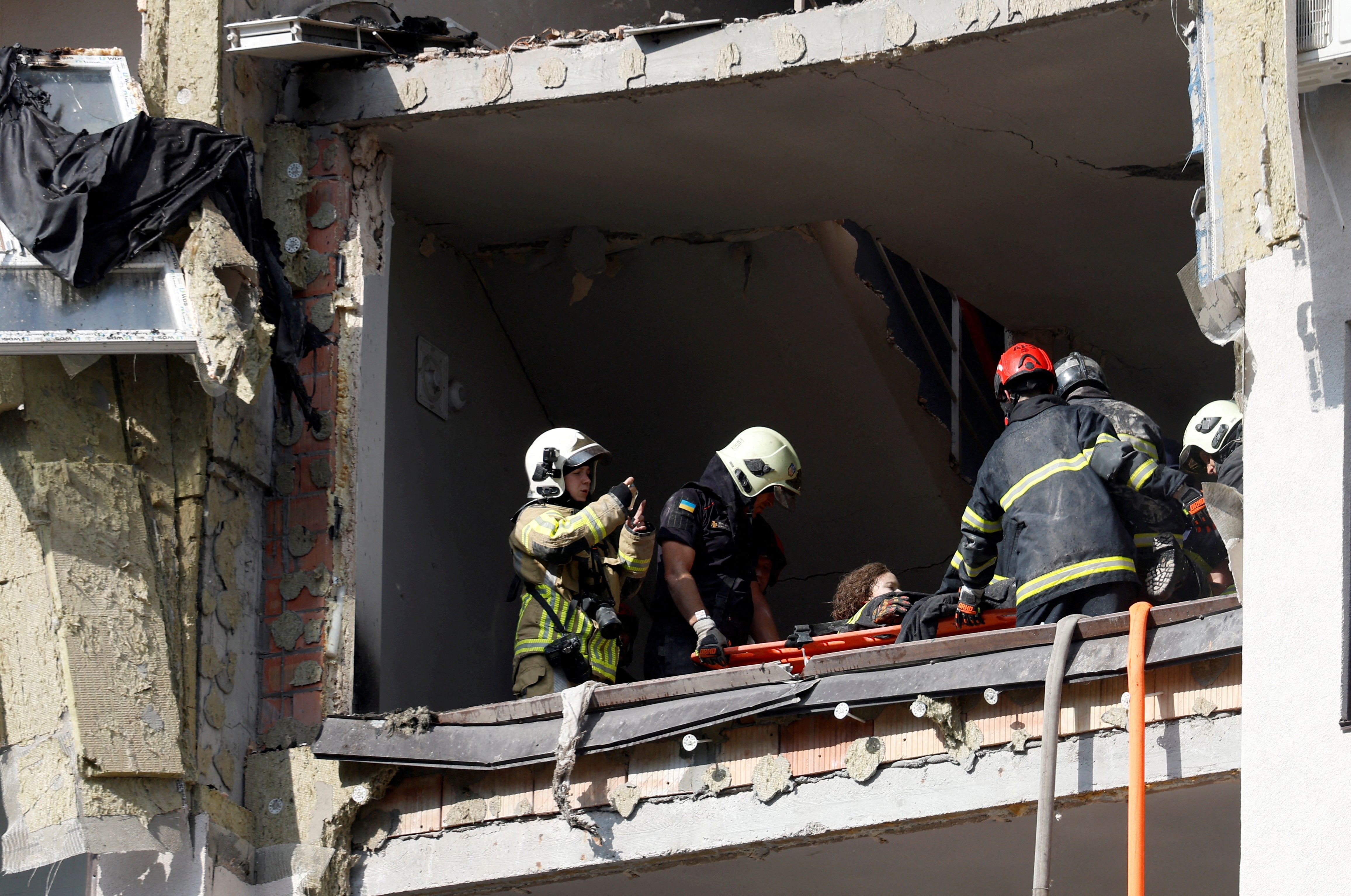 Rescue workers evacuate a person from a residential building damaged by a Russian missile strike