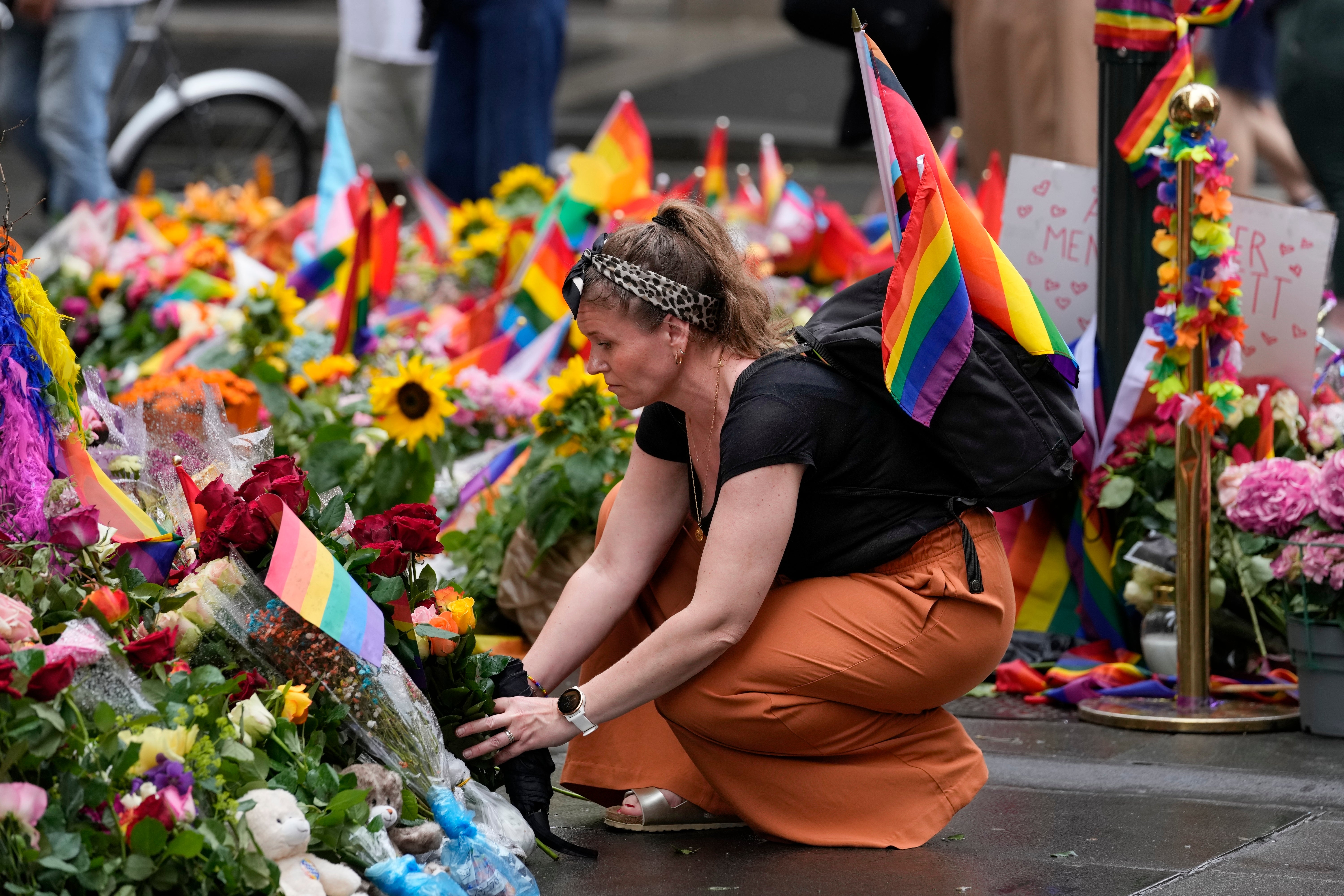 A woman lays flowers at the crime scene on Sunday