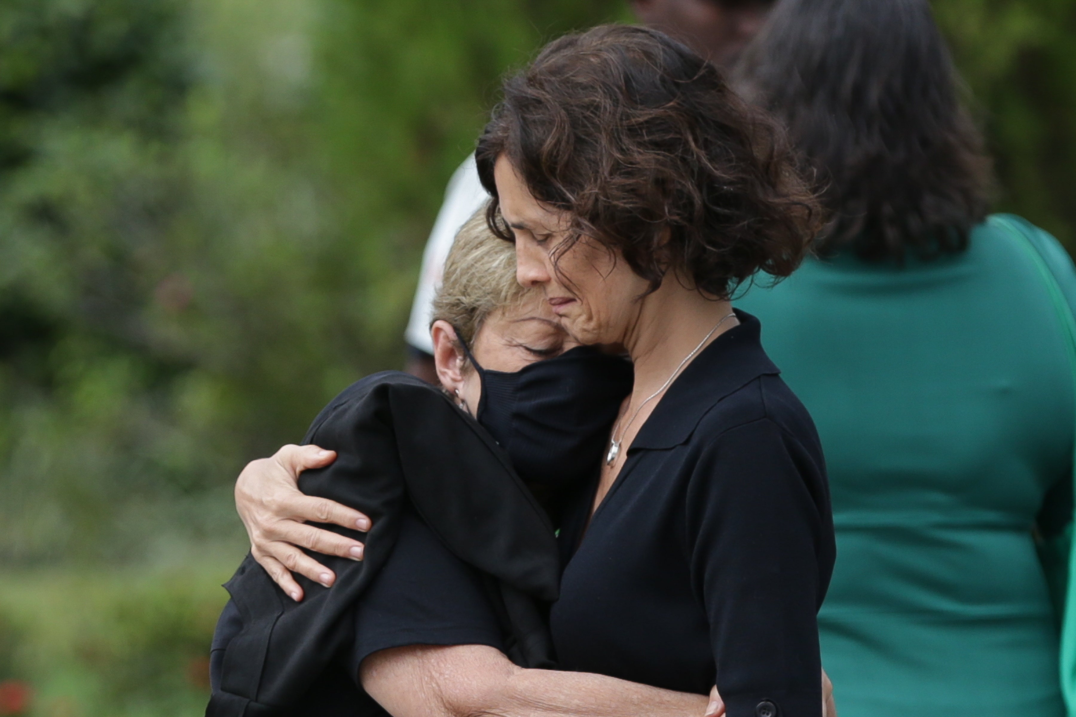 Alessandra Sampaio (R) embraces her mother Maria Lucia Farias Sampaio at her husband’s funeral service