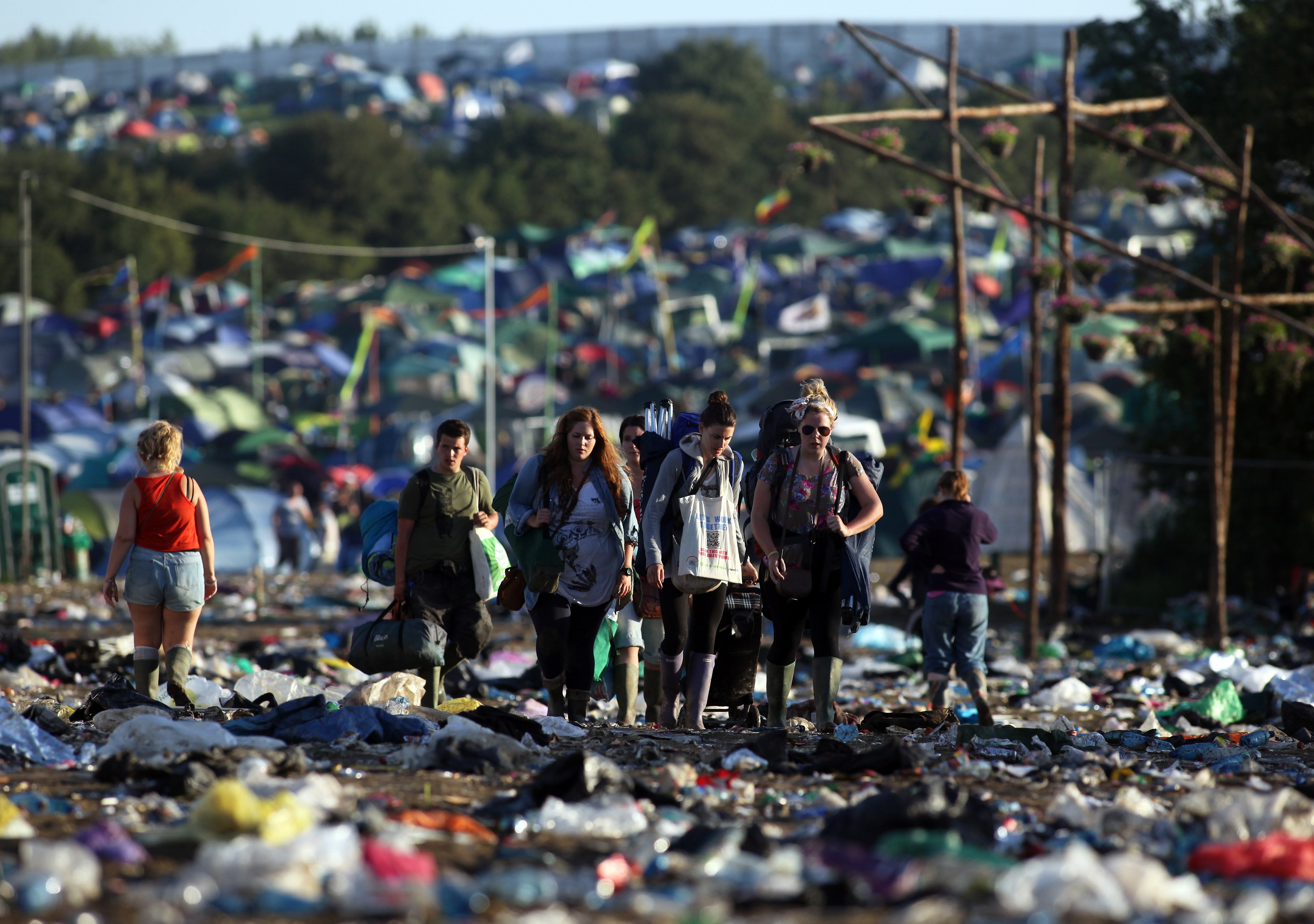 Festival-goers walk through rubbish as they begin to leave Glastonbury in 2011.