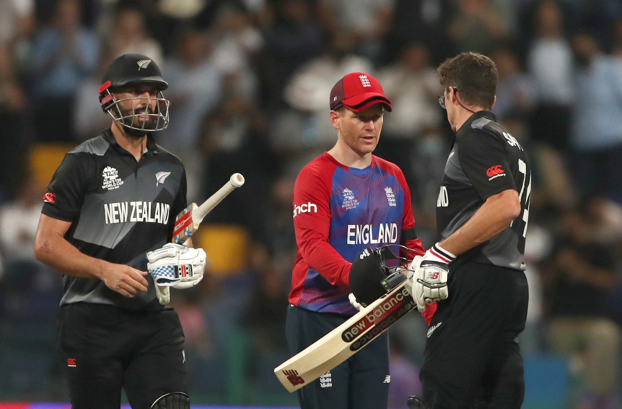 Morgan congratulating New Zealand’s Daryl Mitchell and Mitchell Santner after defeat in the T20 World Cup semi final match (PA Wire)