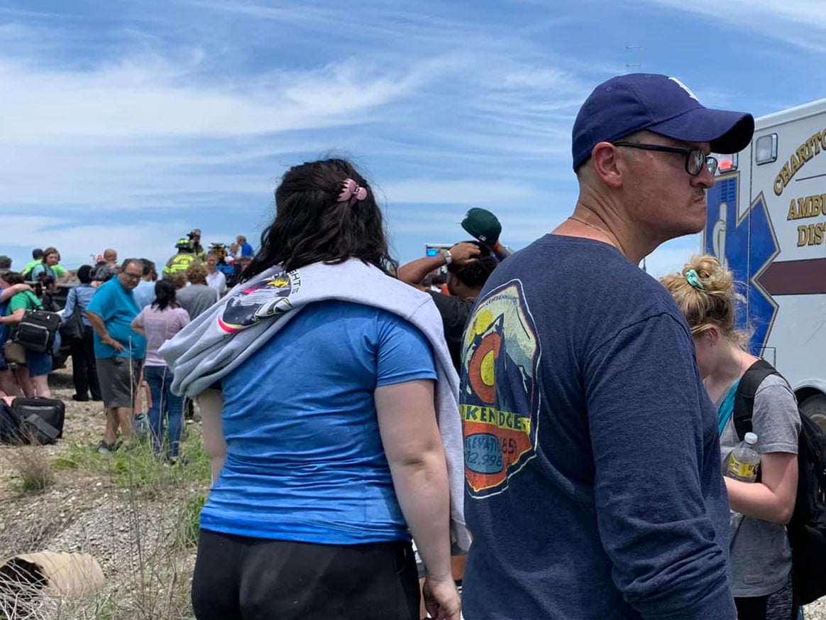 Jason Drinkard (right, wearing baseball cap) was taking a group of Kansas high school students to Chicago for a business competition when their Amtrak train derailed.