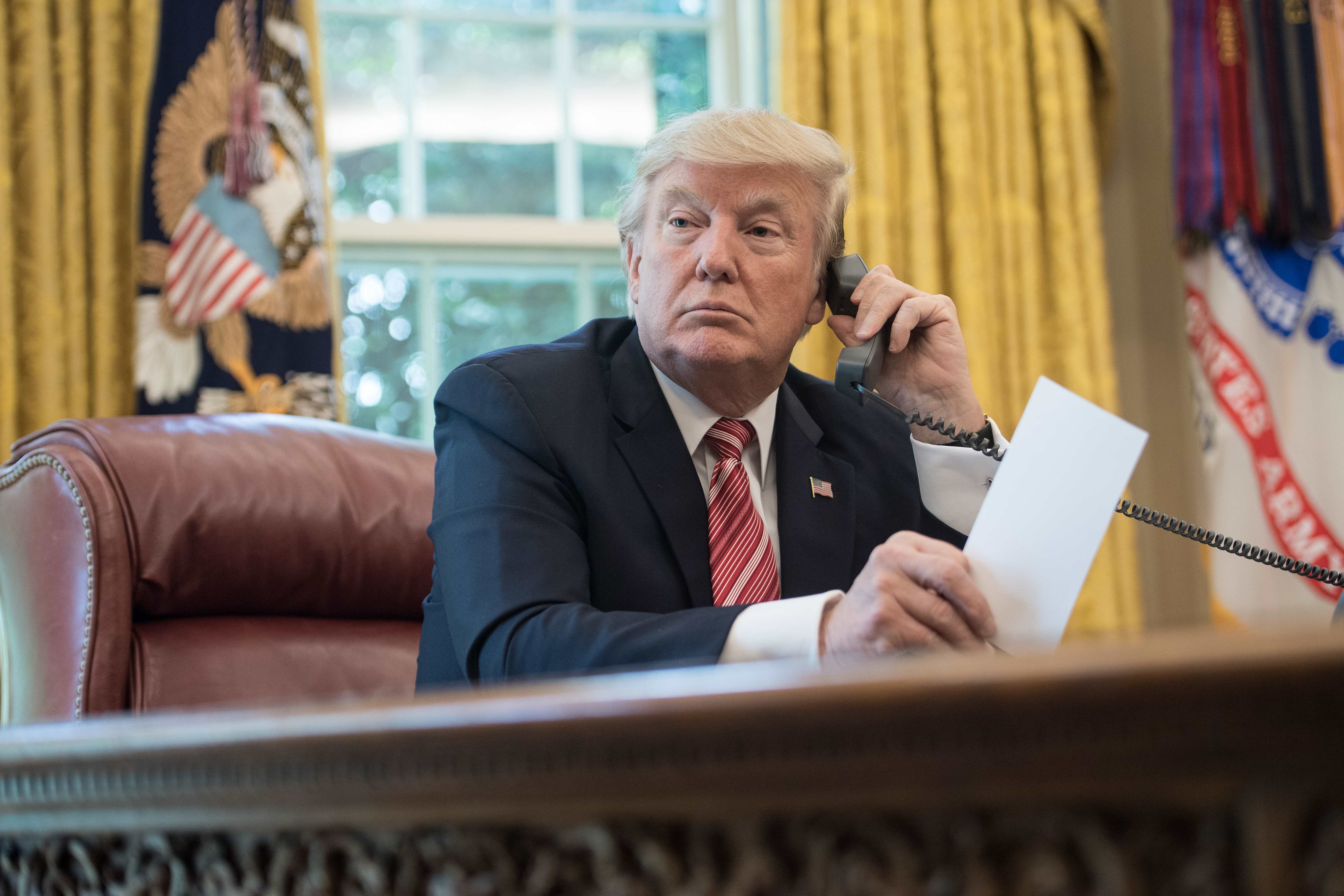 Donald Trump putting in a call from the Resolute Desk