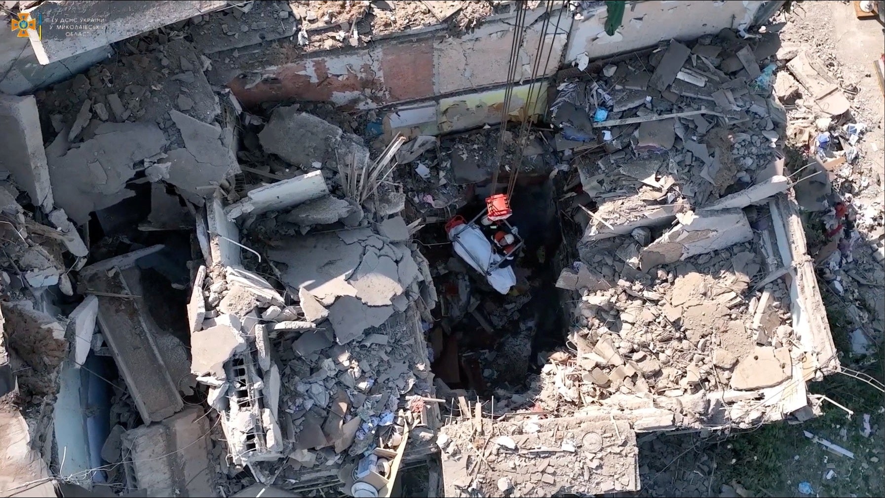 Rescue workers pull out a body from a residential building hit by a Russian military strike