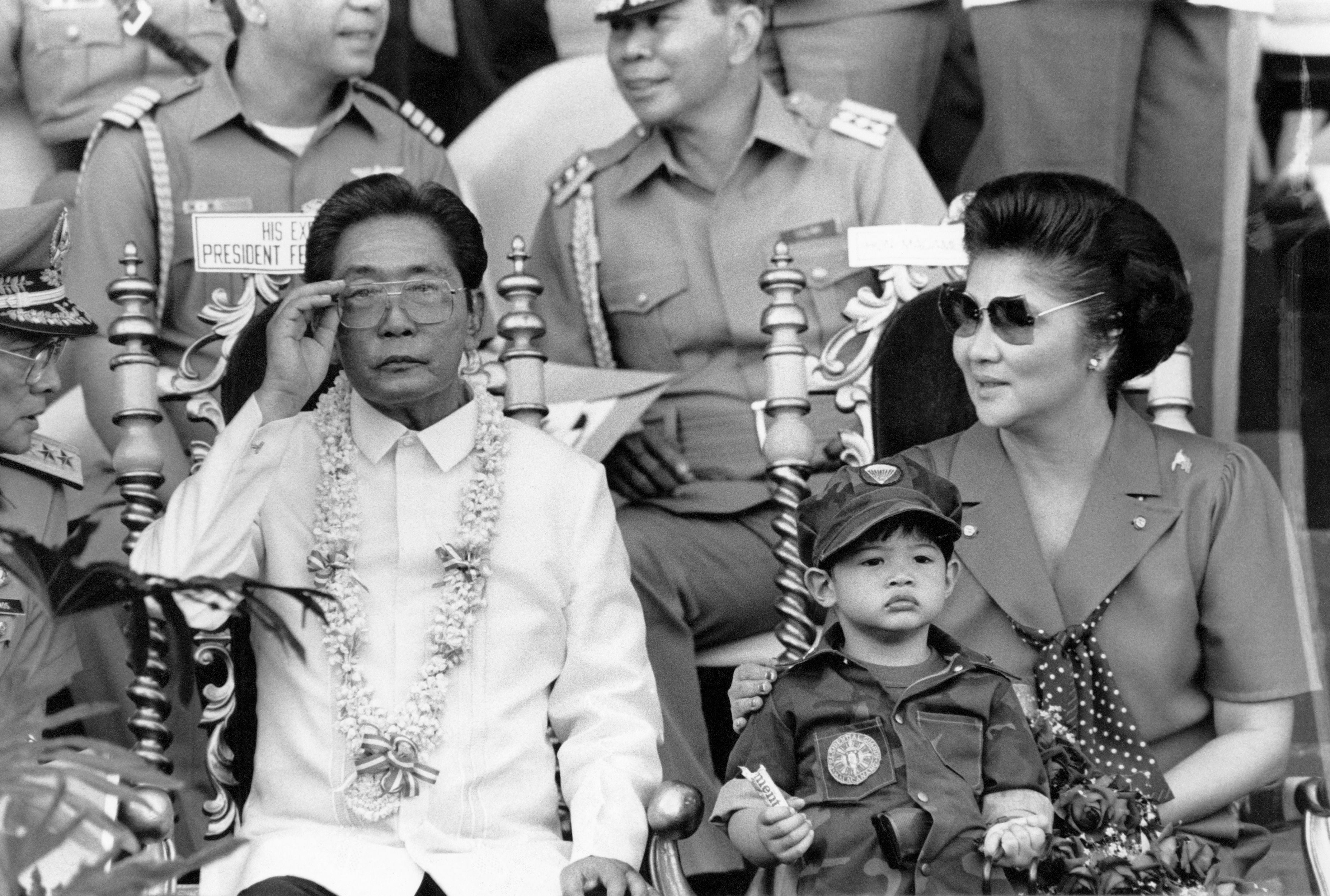 President Ferdinand Marcos and his wife Imelda look on at 35,000 college students undergoing compulsory military training in Manila in 1985