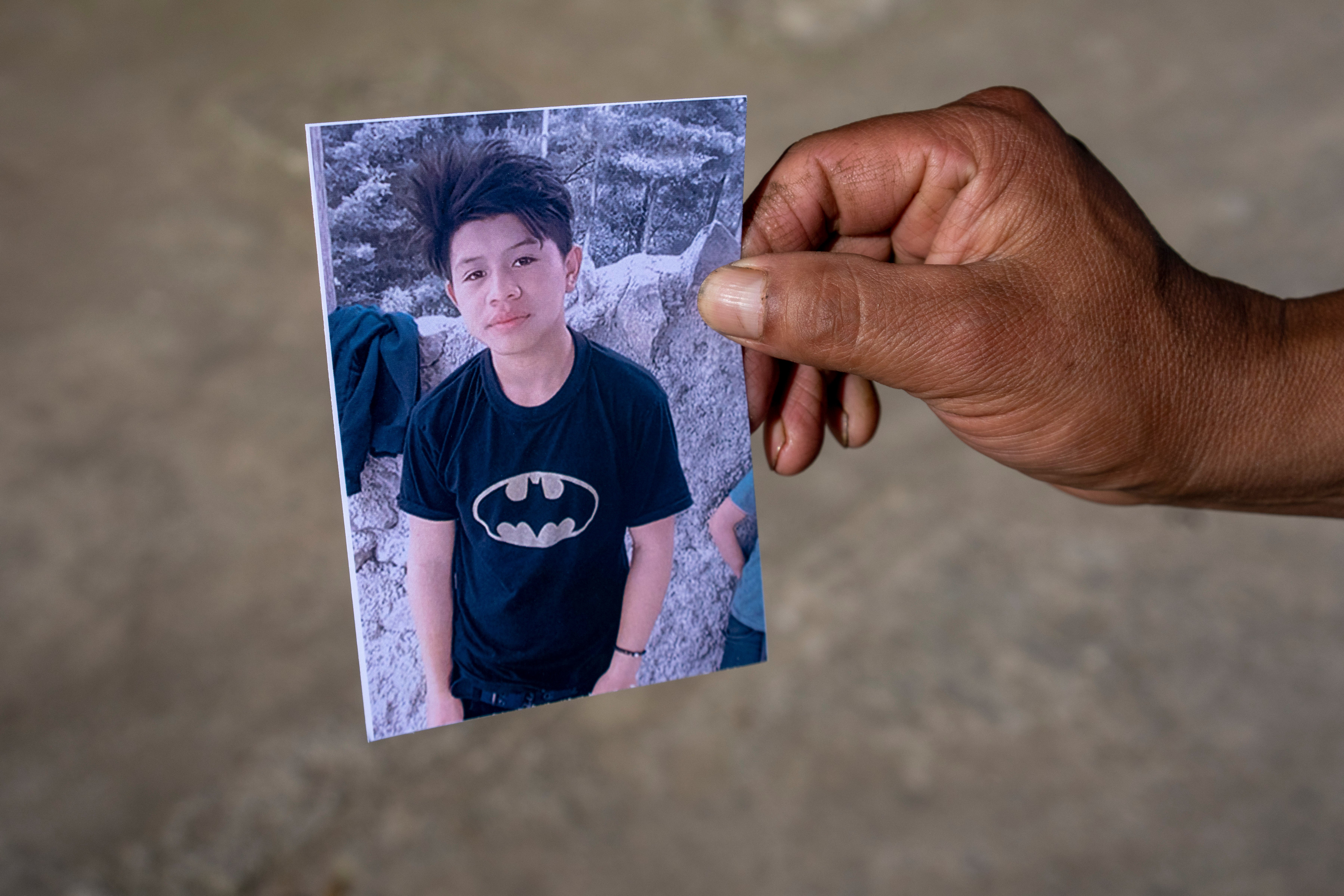 A man shows a portrait of Wilmer Tulul, in Tzucubal, Guatemala, Wednesday, June 29, 2022