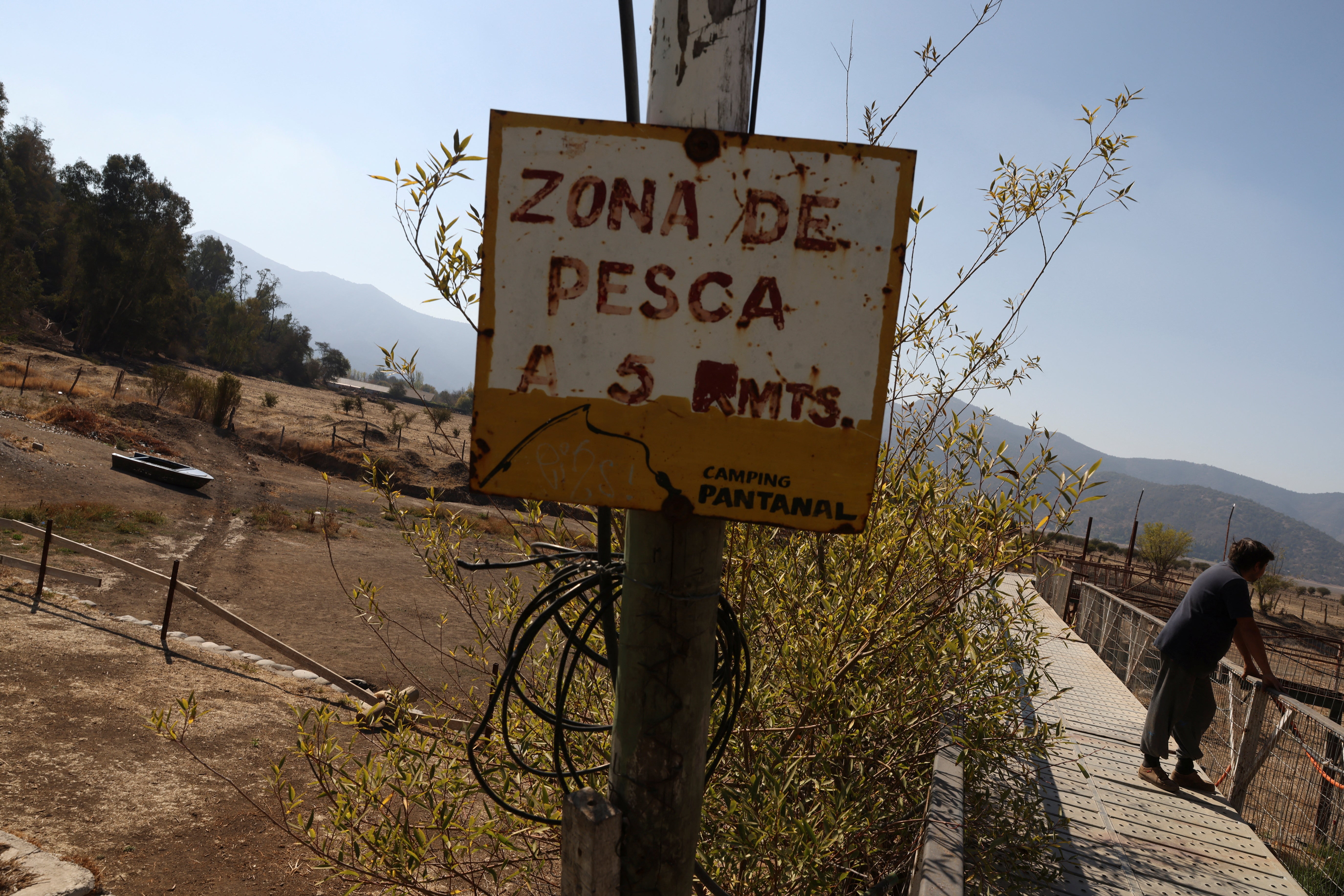 A sign reading ‘zona de pesca’ (fishing area) hangs next to a pier at the former Aculeo lagoon at Paine