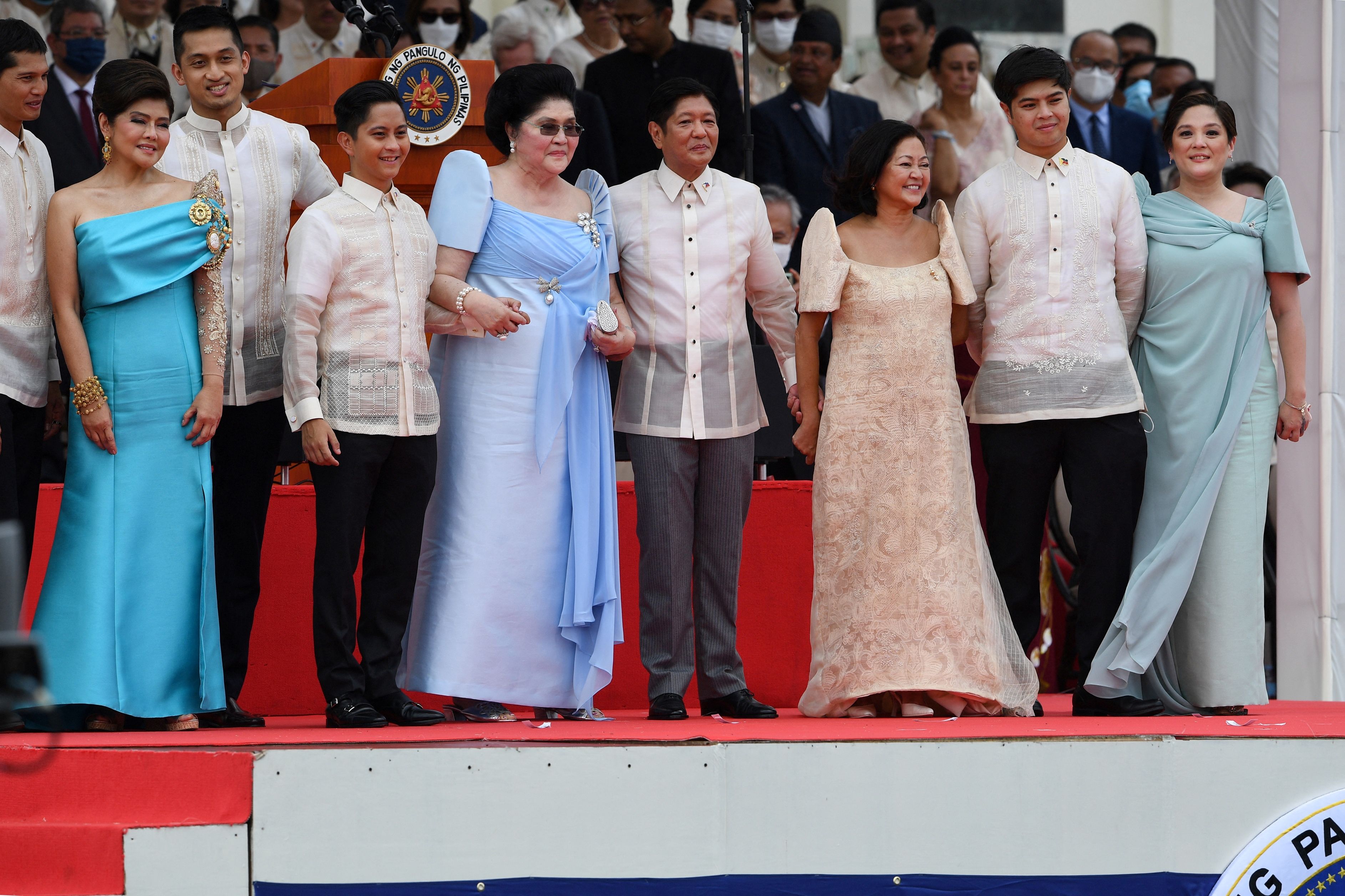 Former first lady Imelda Marcos (fifth left) holds hands with her son, the new Philippine president, Ferdinand Marcos Jr (centre), alongside family members after he took his oath of office