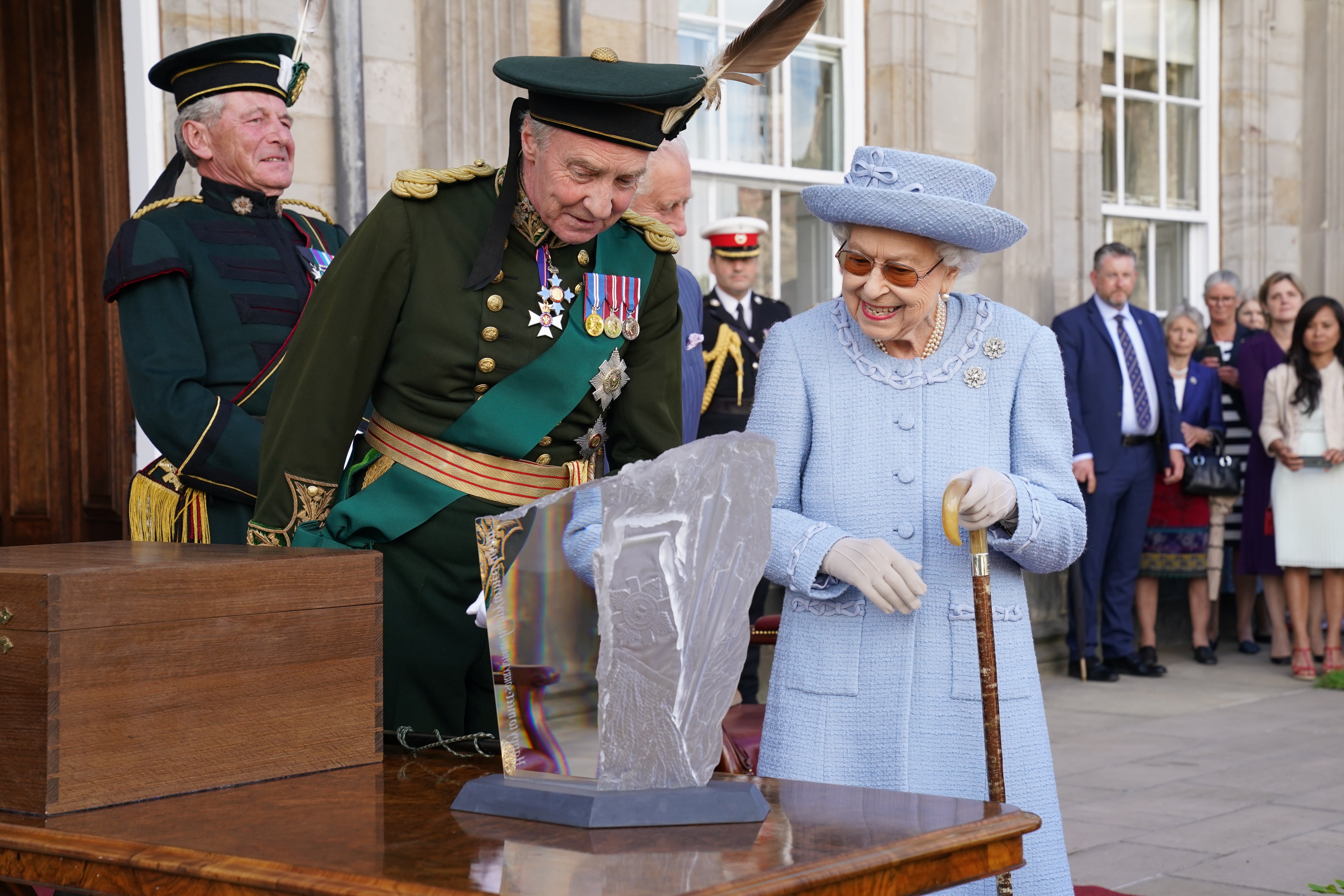 The Duke of Buccleuch presents a carving to the Queen as they attend the Queen’s Body Guard for Scotland (also known as the Royal Company of Archers) Reddendo Parade in the gardens of the Palace of Holyroodhouse, Edinburgh (Jane Barlow/PA)