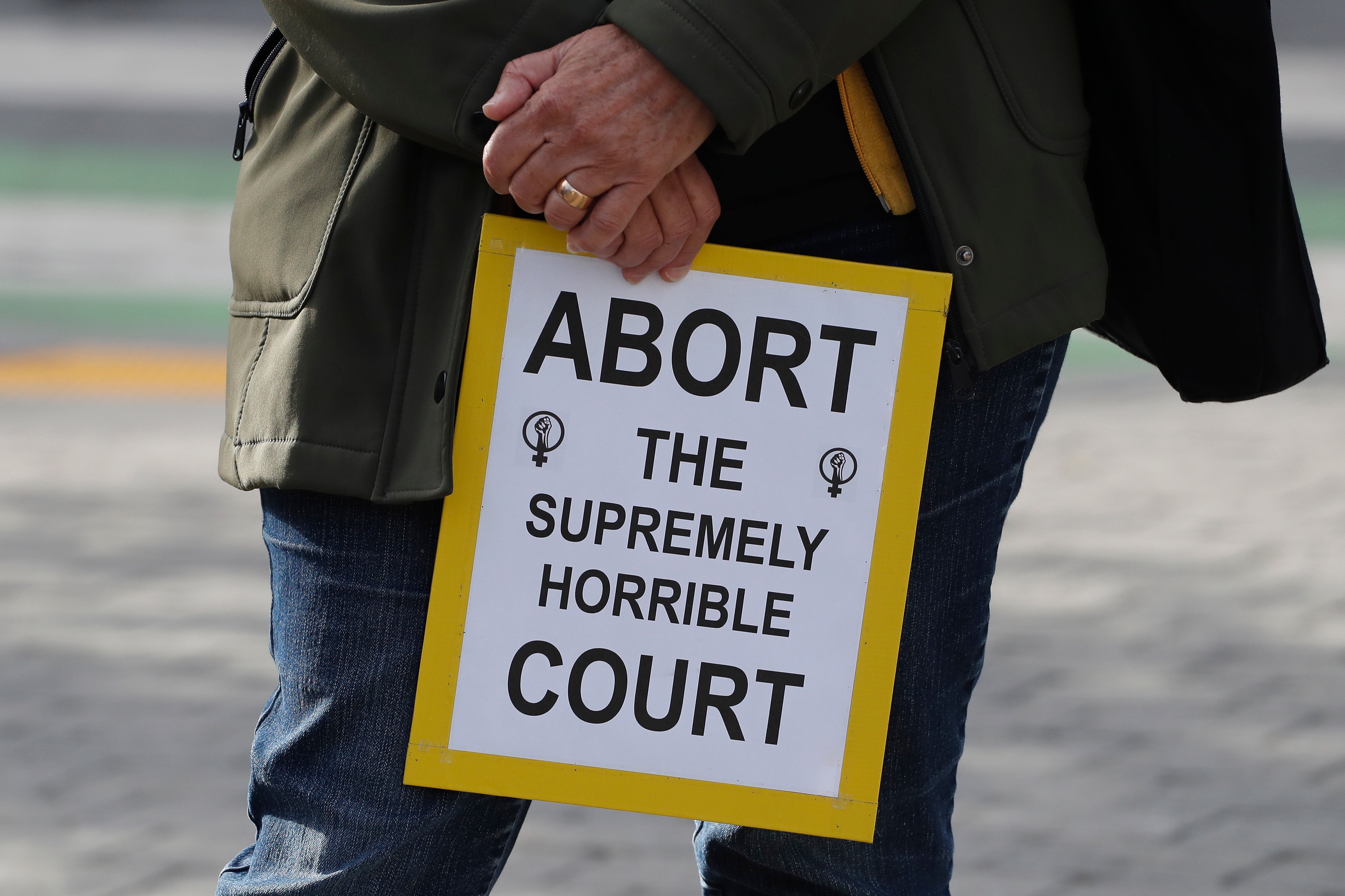 A person holds a placard as abortion rights activists march by cafes and restaurants in the Hayes Valley district in San Francisco