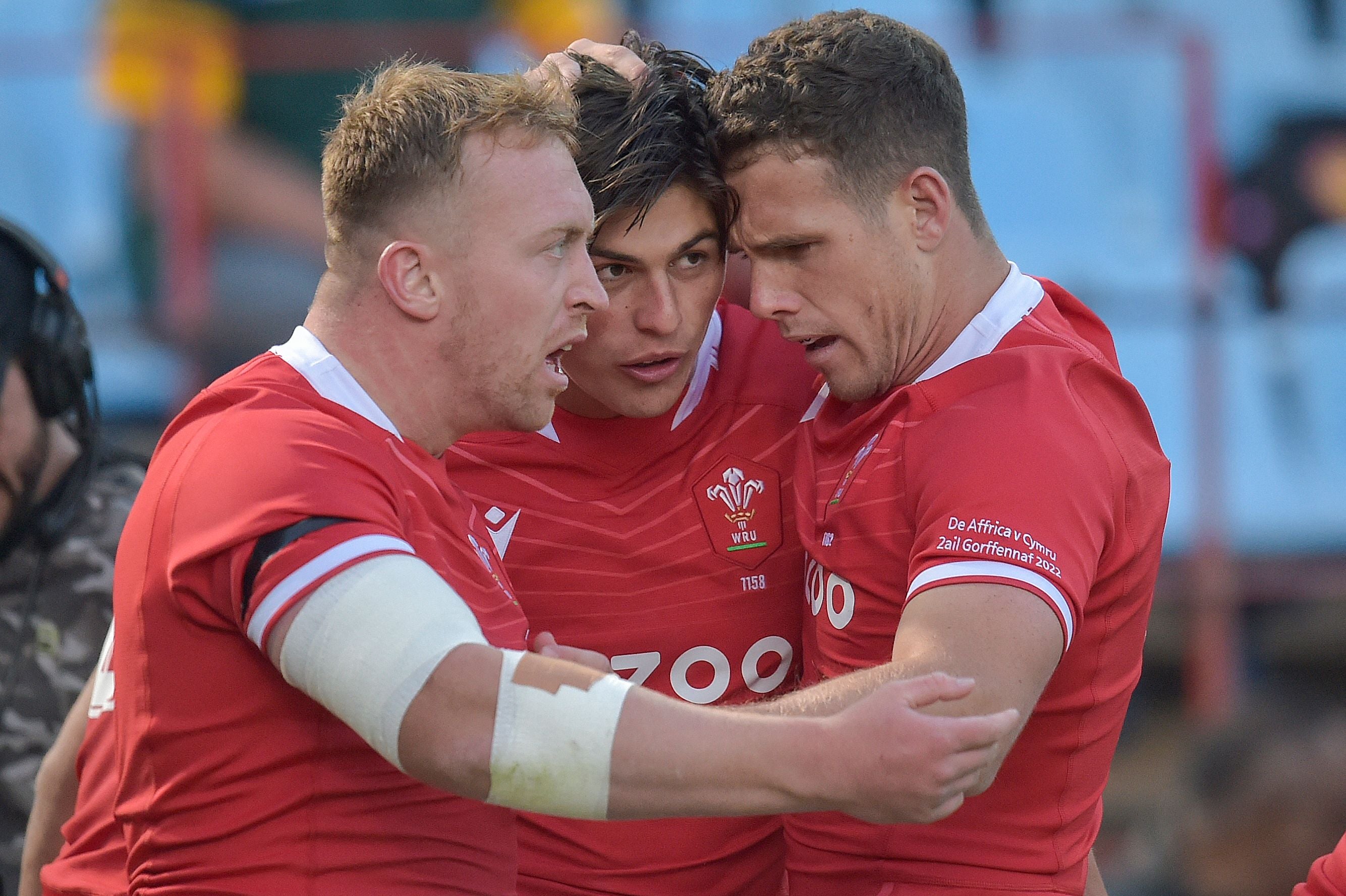 Rees-Zammit (centre) celebrates with teammates after scoring the first Welsh try