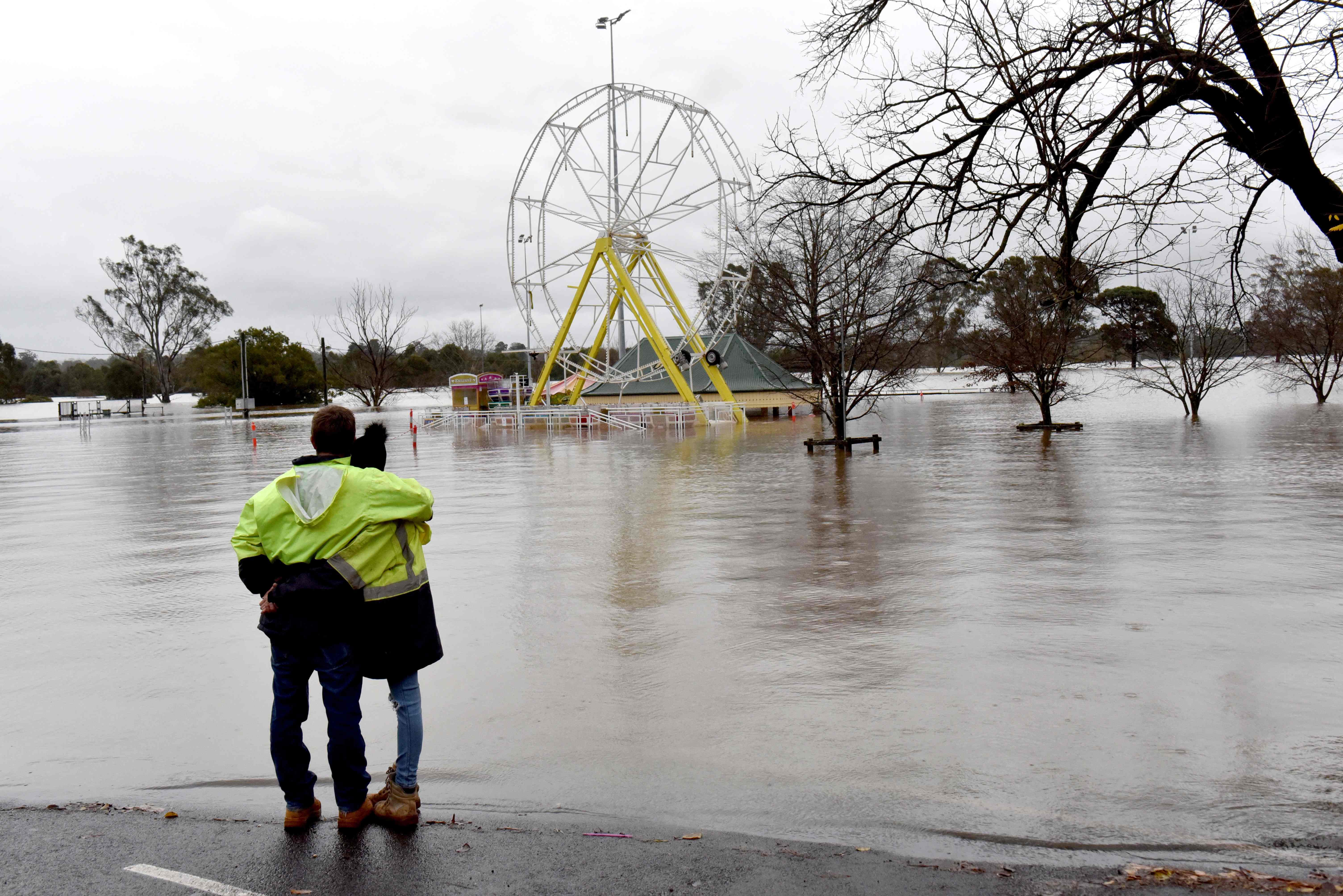 People look at a flooded park due to torrential rain in the Camden suburb of Sydney