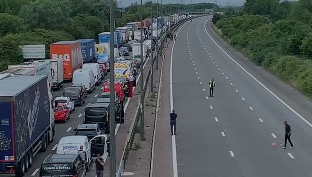 A group of men played football on the motorway while stuck in traffic