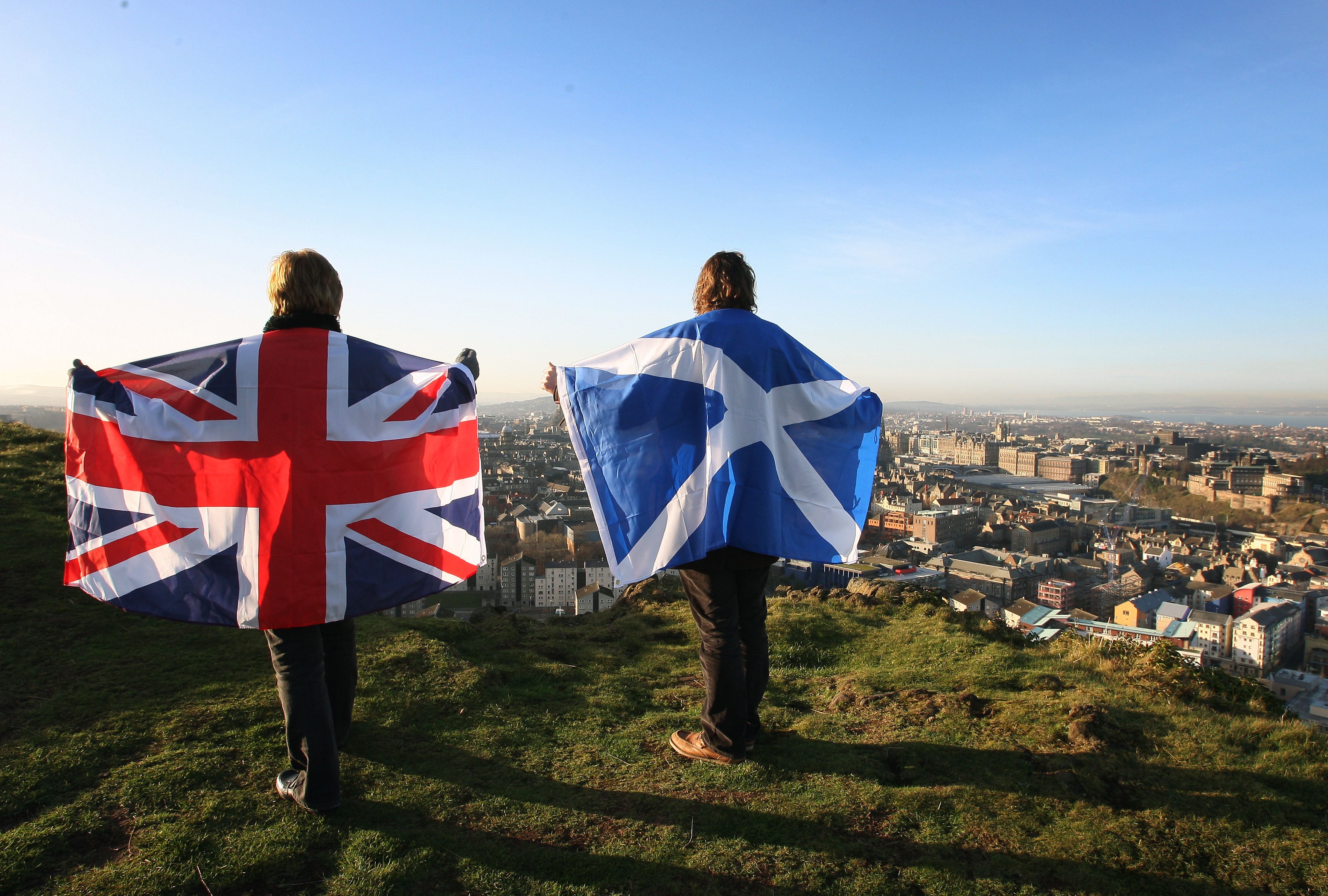 Scottish and English flags held up over Edinburgh, Scotland