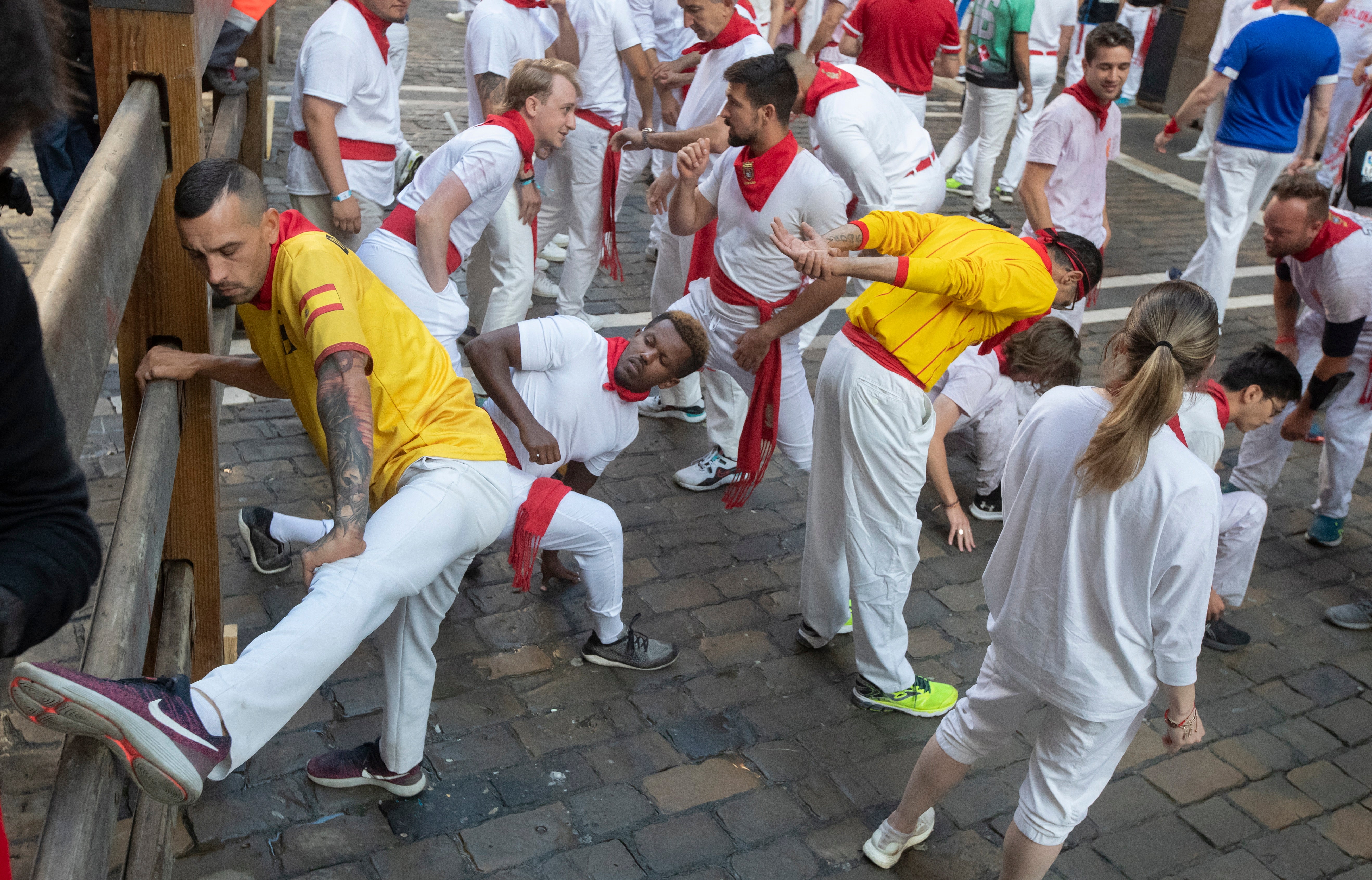 People stretch prior to the traditional running of the bulls