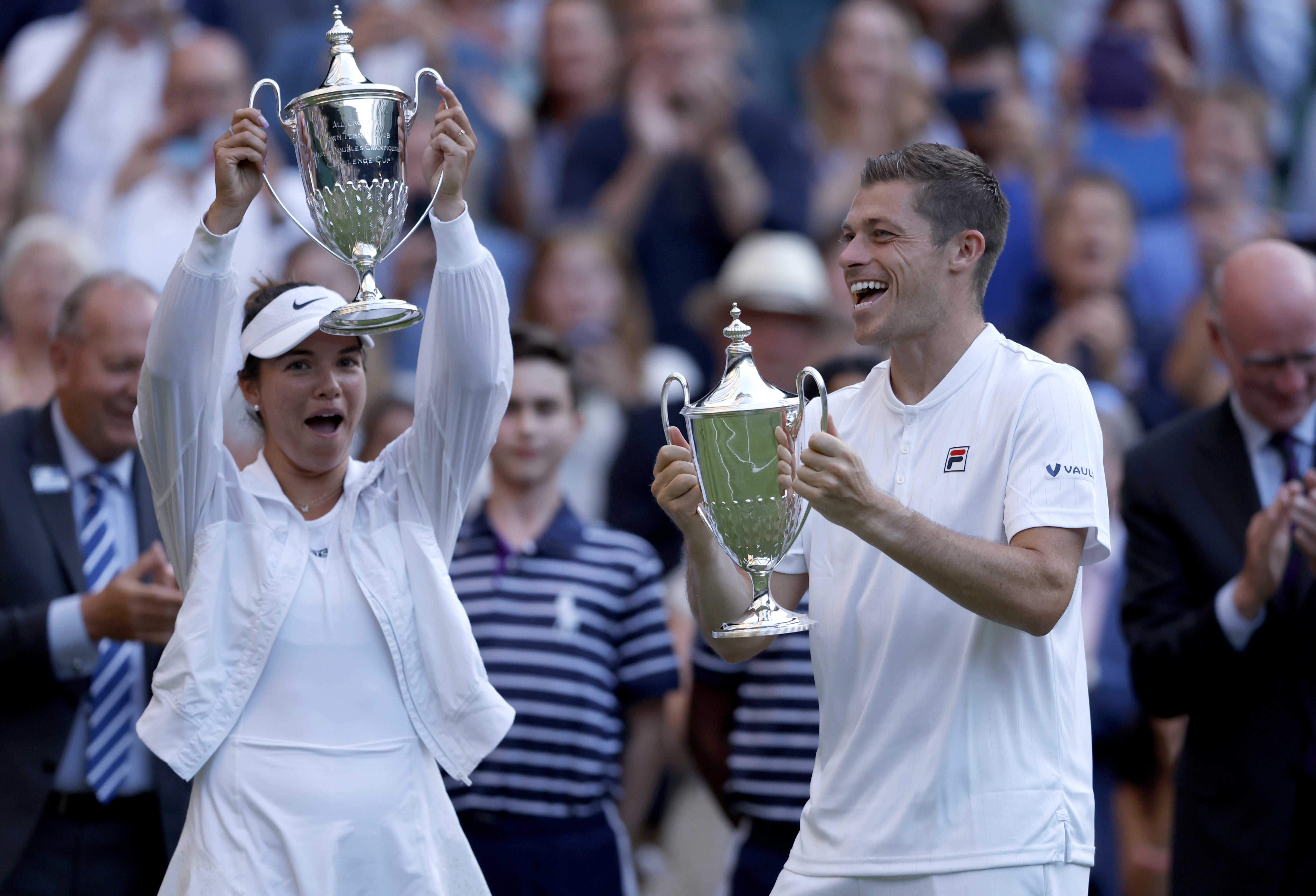 Neal Skupski and Desirae Krawczyk (left) lift their mixed doubles trophies (Steven Paston/PA)