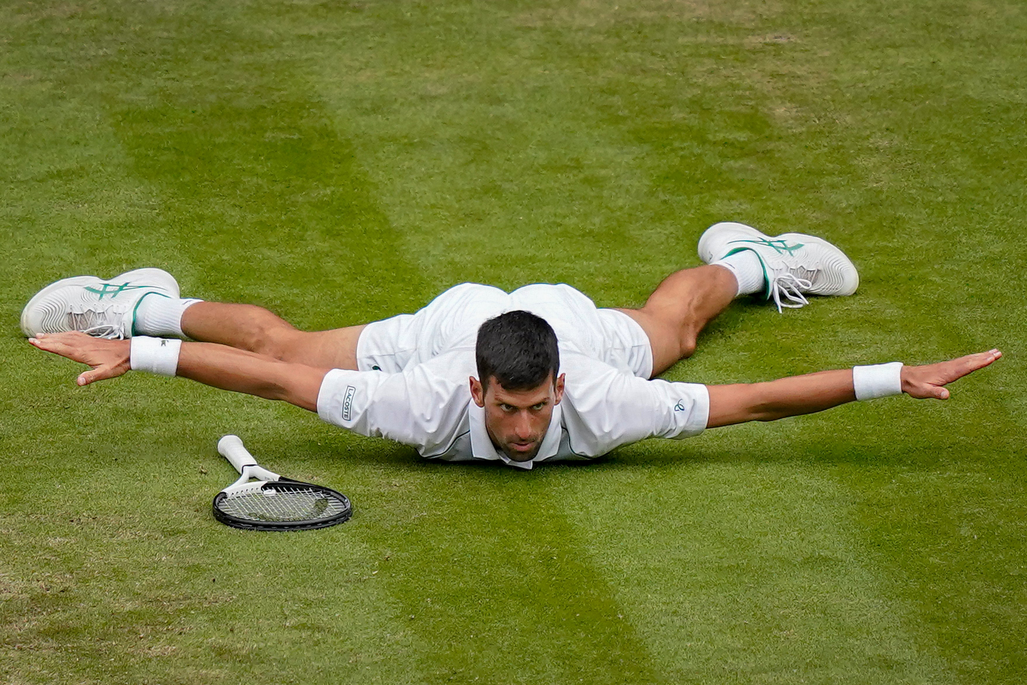 Novak Djokovic lies on his chest after a terrific winner against Jannik Sinner at Wimbledon 2022