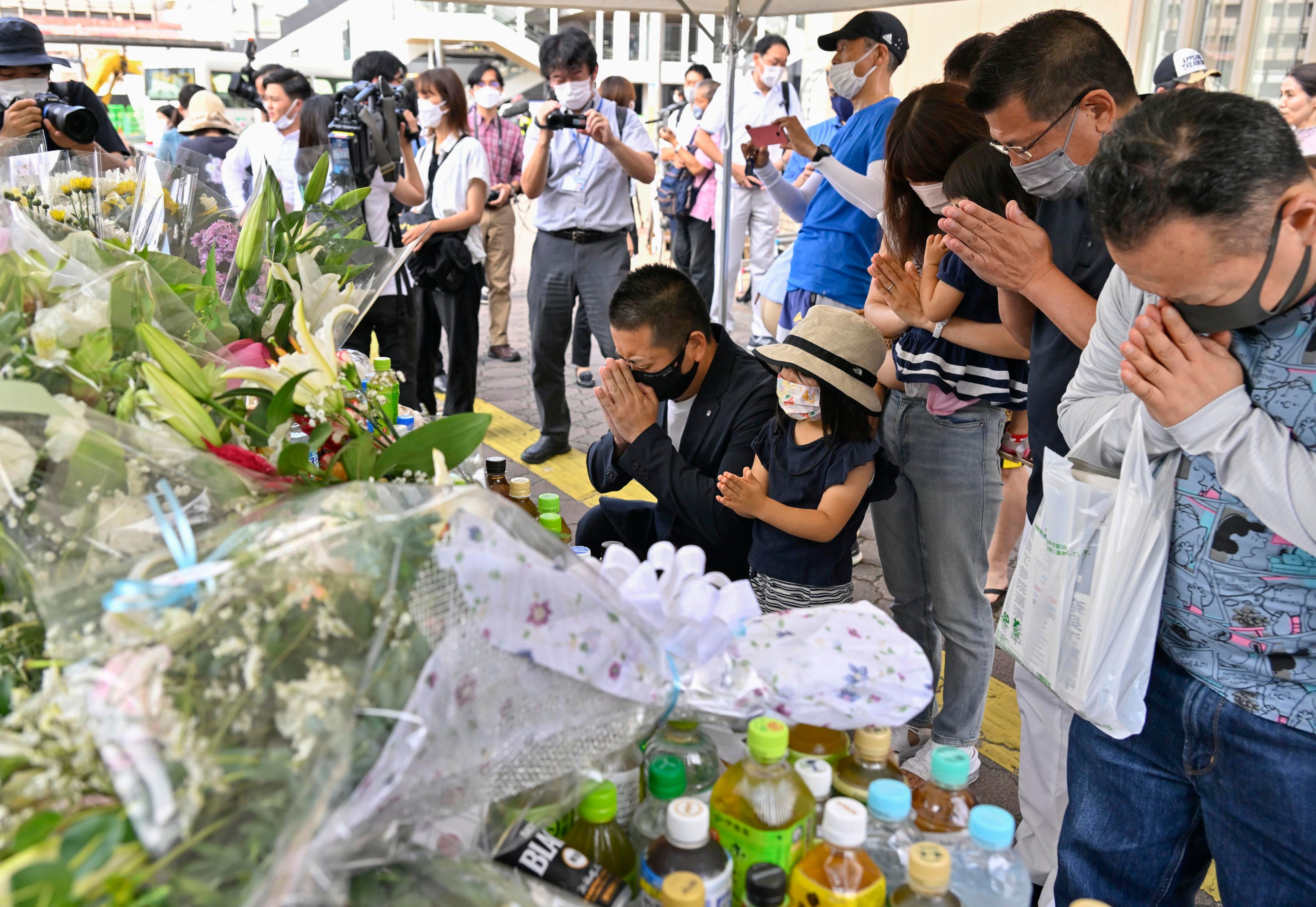 People pray at a makeshift memorial near to the scene where the former prime minister Shinzo Abe was shot