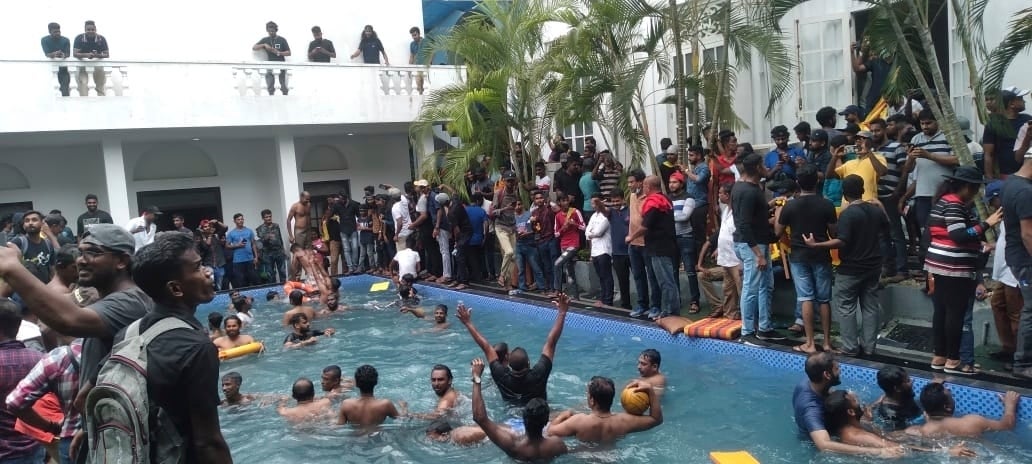 Anti government protesters swim in a swimming pool of the Sri lankan president's official residence