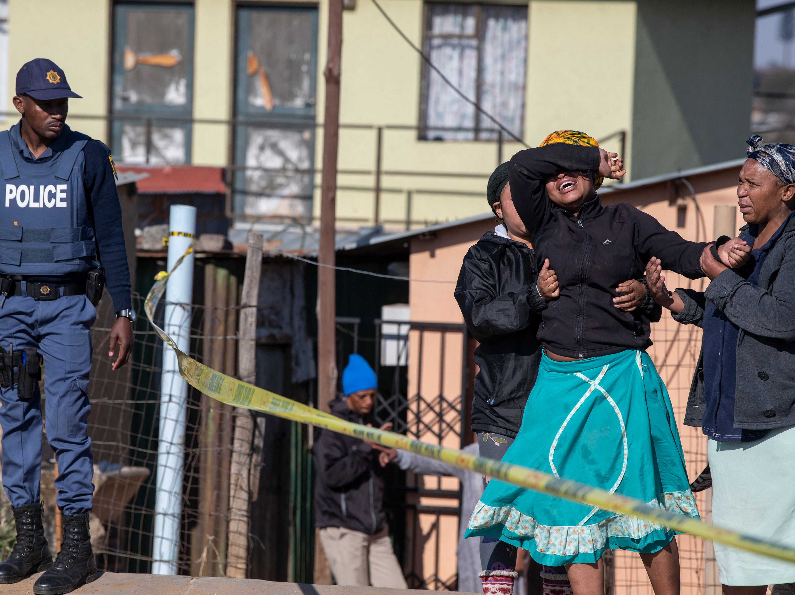 A relative of one of the victims cries at a police cordon outside the tavern