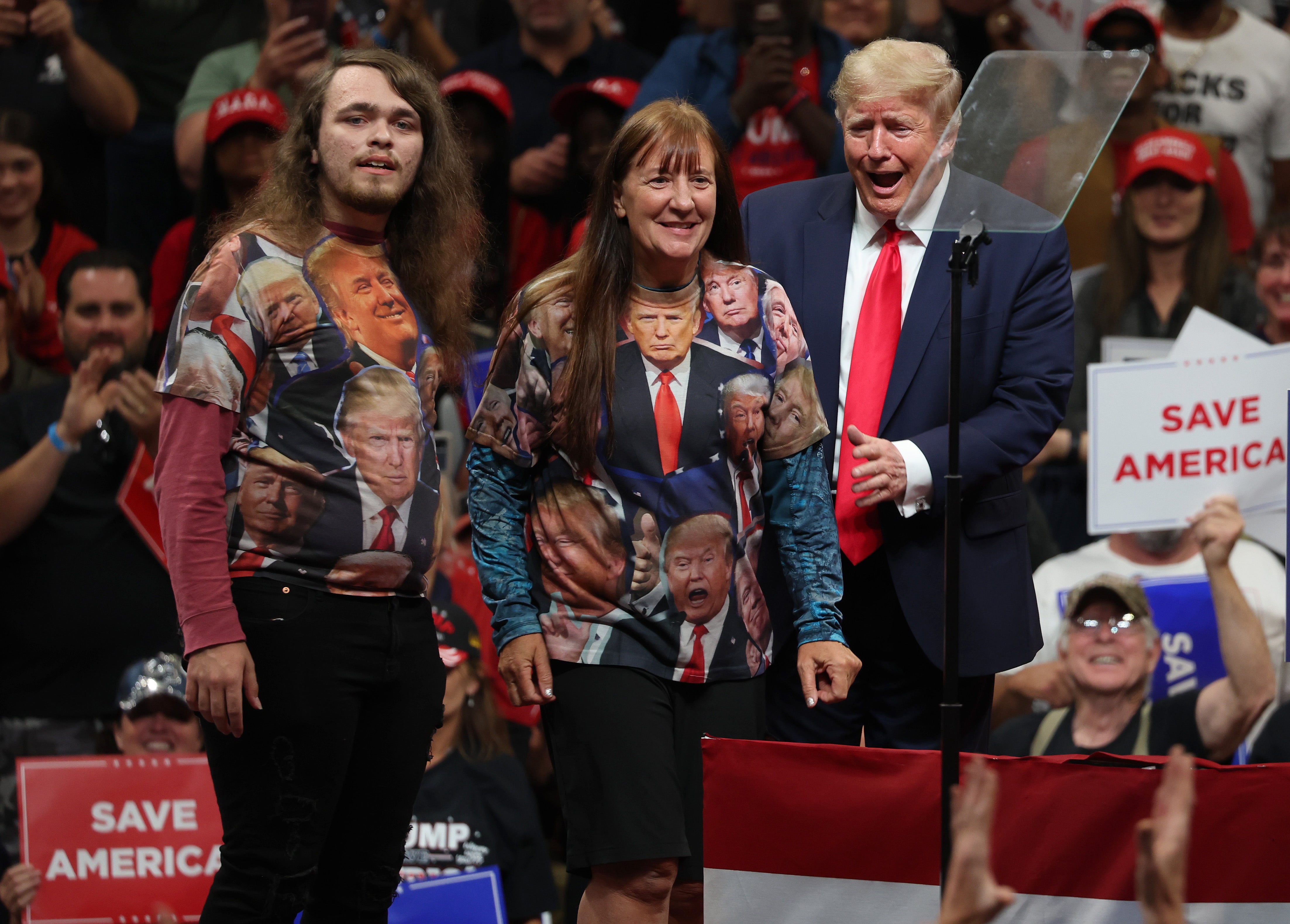 Donald Trump brings two fans on stage wearing shirts covered in the former president’s picture