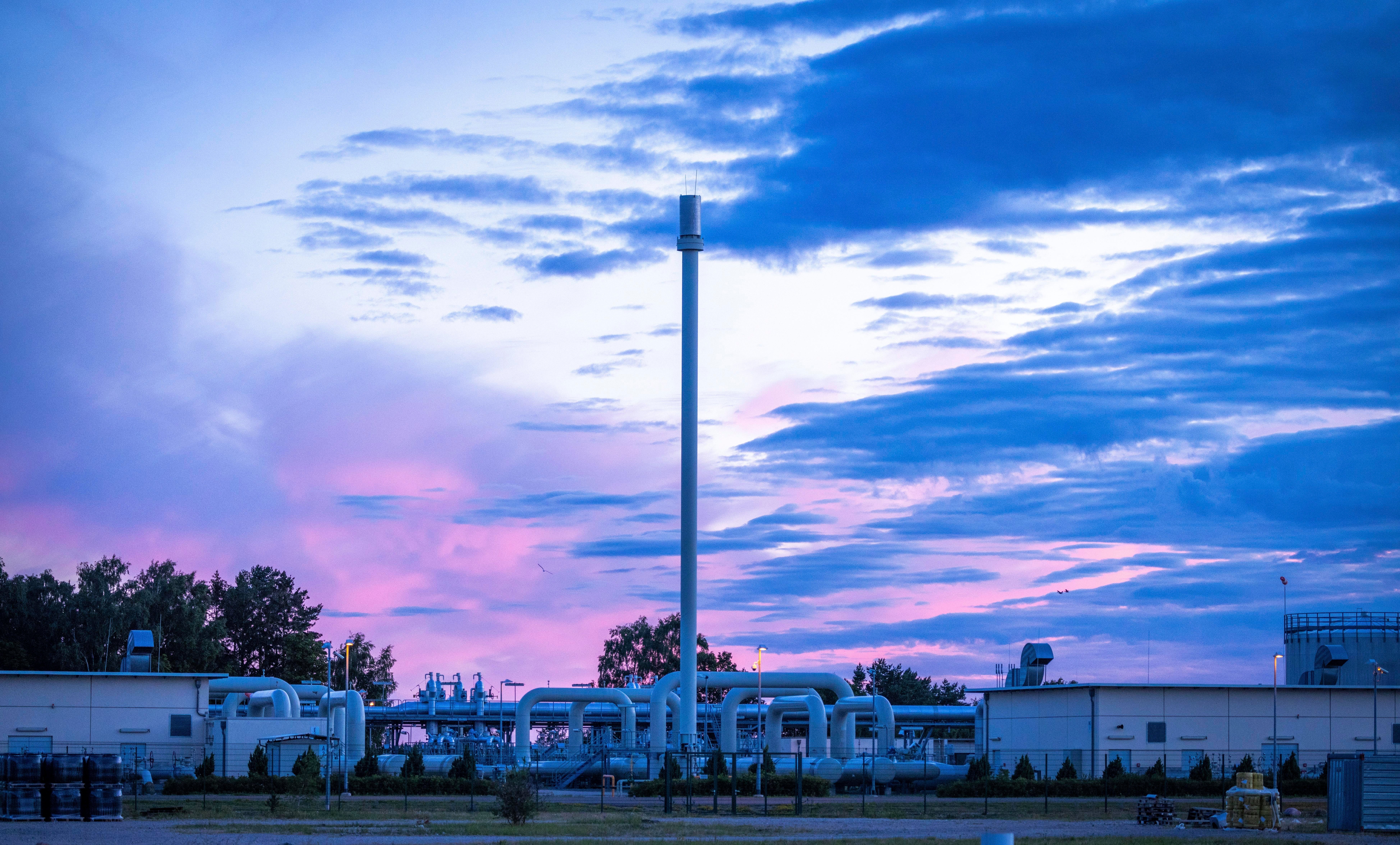 The sun rises behind the pipe systems and shut-off devices of the Nord Stream 1 gas receiving station in Lubmin, Germany