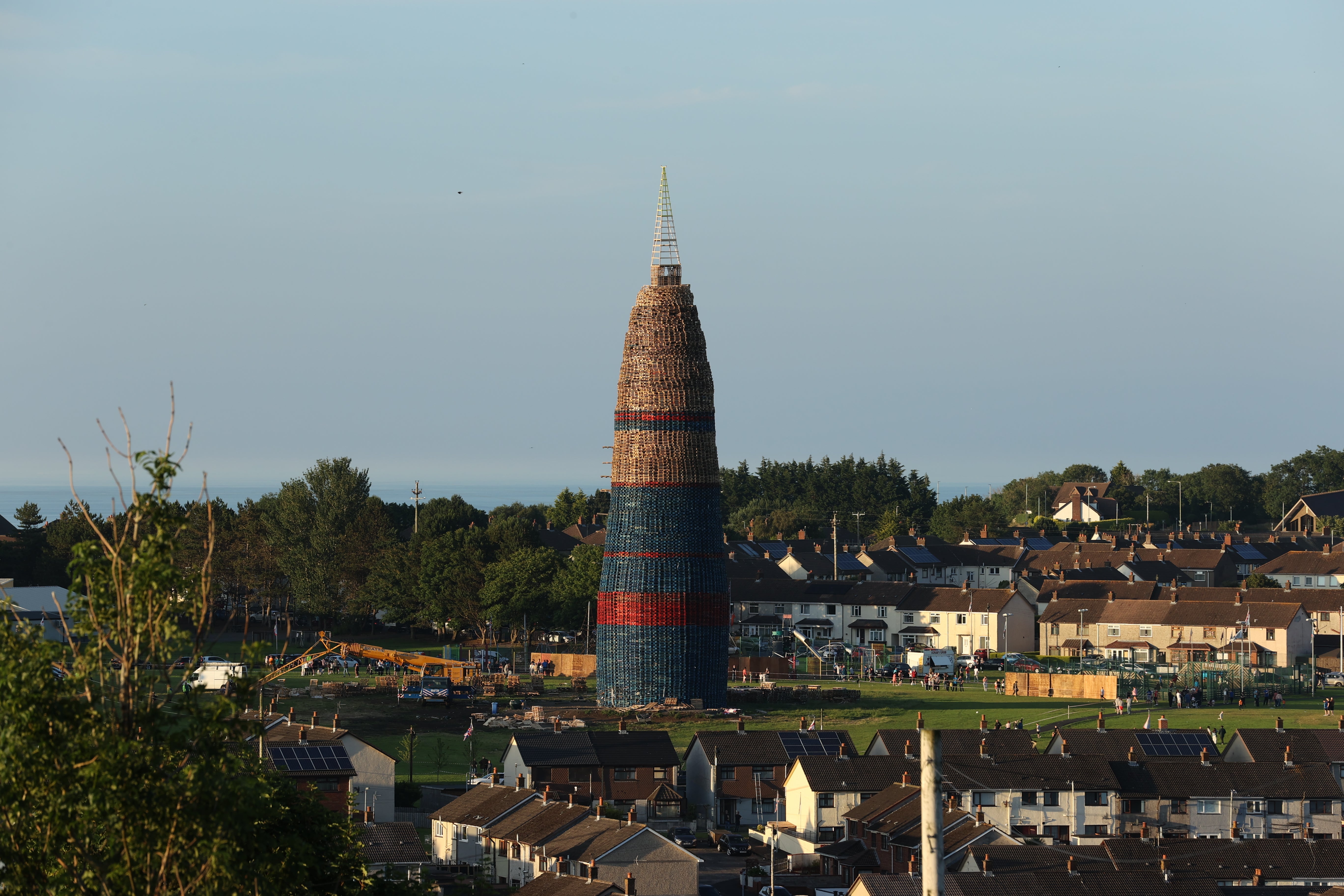 The Craigyhill Bonfire on the Craigyhill estate, Larne, Co Antrim, the builders are attempting to break a world record for the tallest bonfire, which currently stands at 198 feet. The builders say they will continue with their record bid in tribute to the man who died after falling from a bonfire on the nearby Antiville estate last night. Picture date: Sunday July 10, 2022.