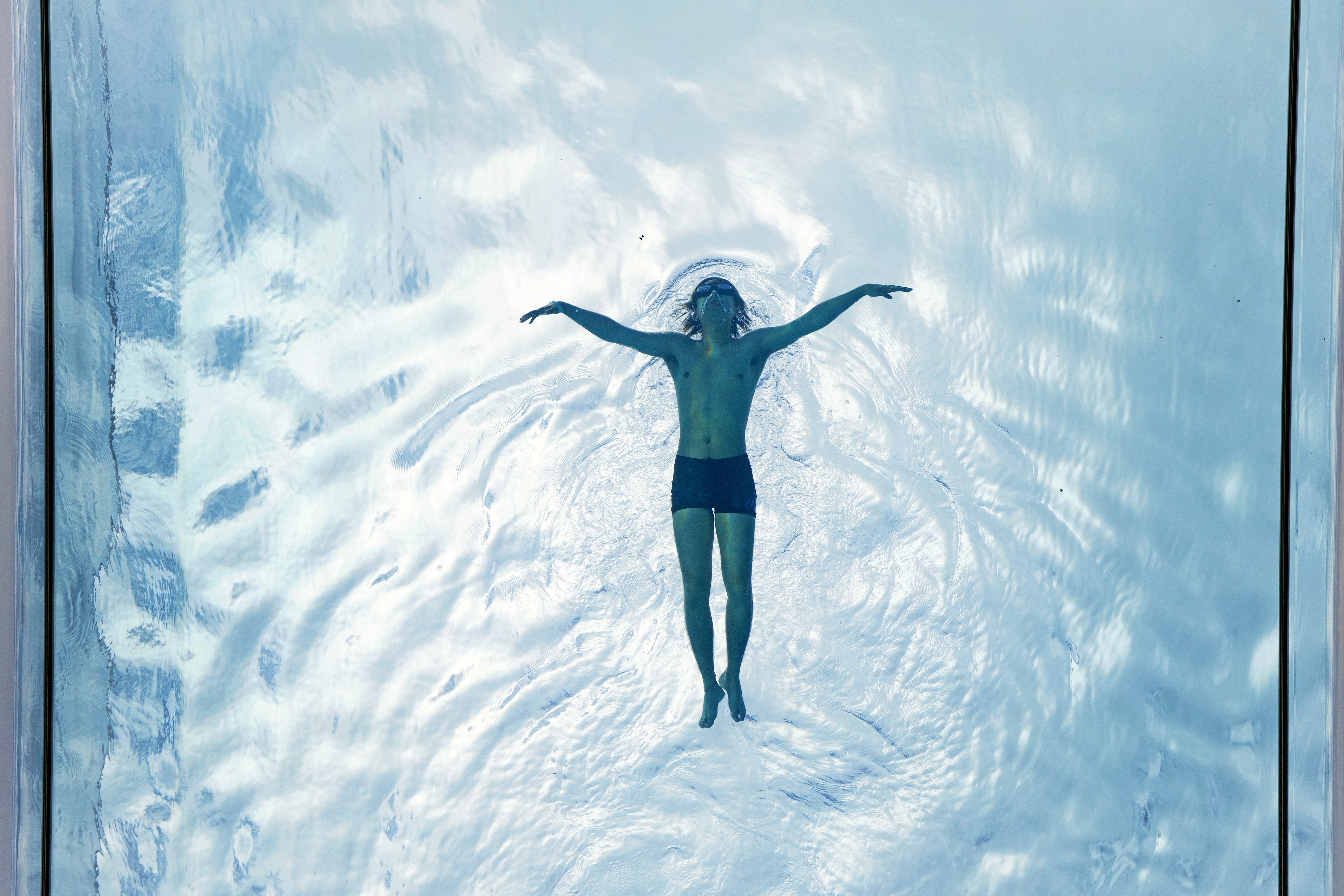 A man swims in the Sky Pool, a transparent swimming pool, in Nine Elms, central London (PA)