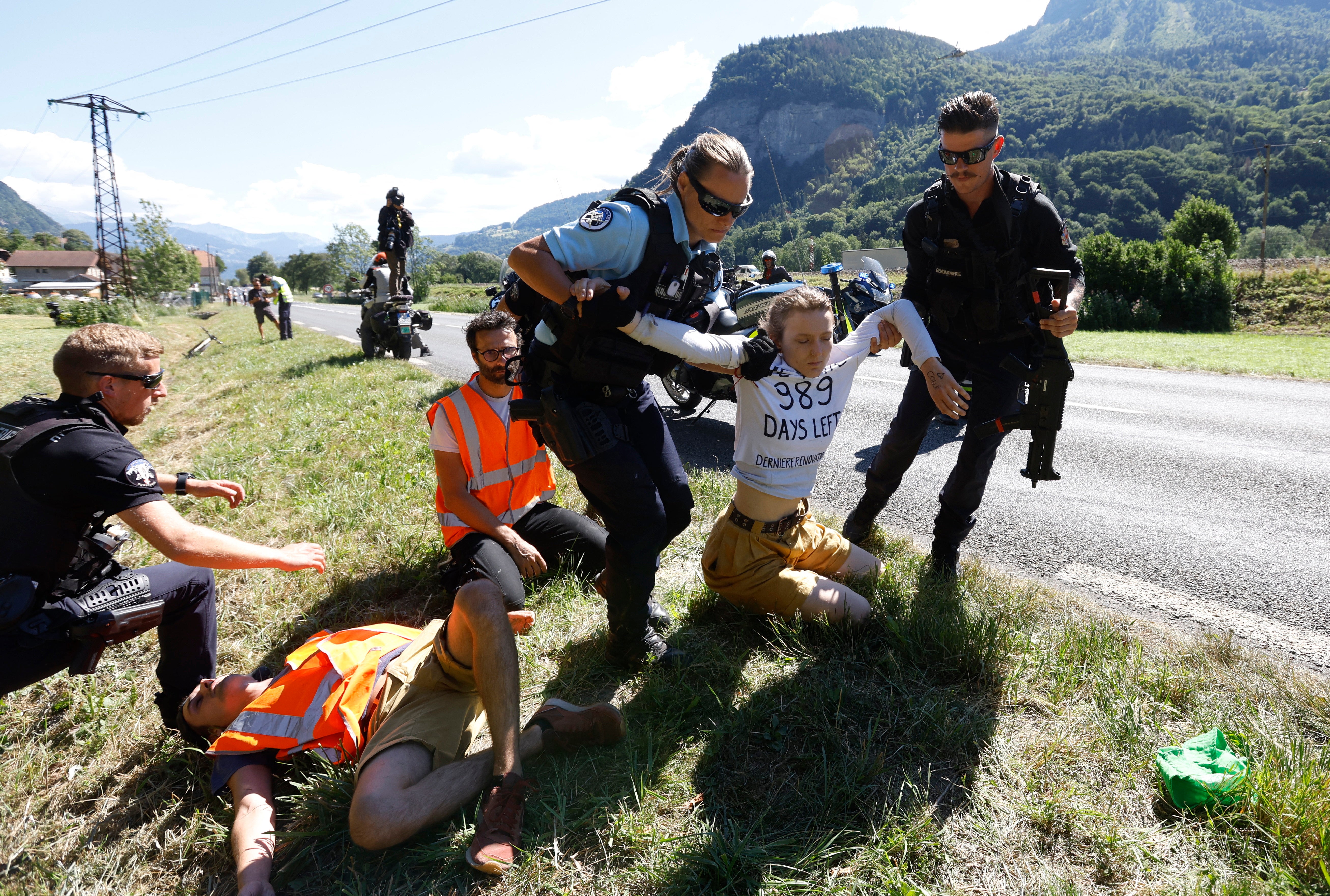 Police officers remove protestors from the road