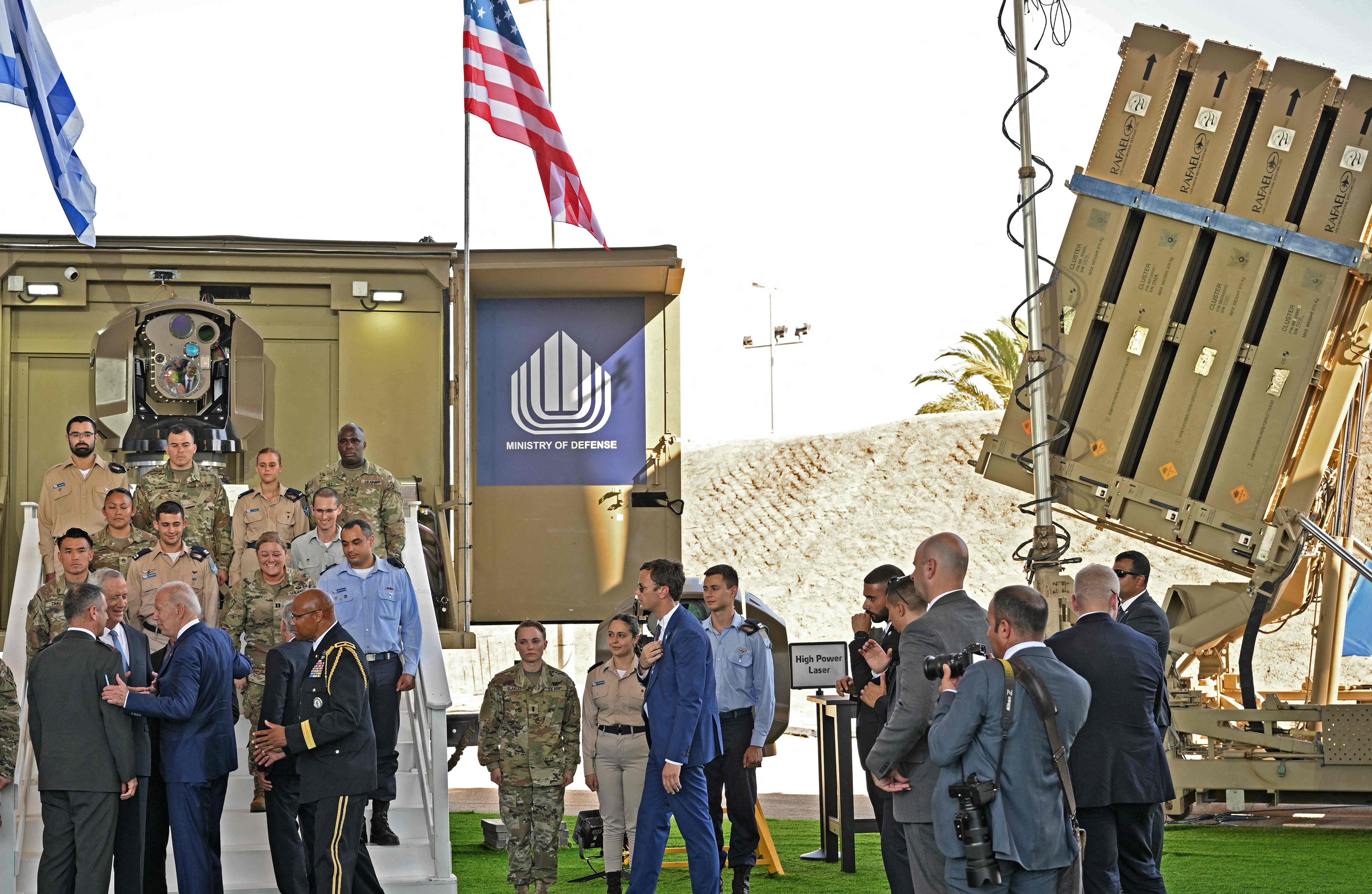 President Joe Biden speaks to Israeli Defence Minister Benny Gantz in front of an Iron Beam (L) and an Iron Dome battery