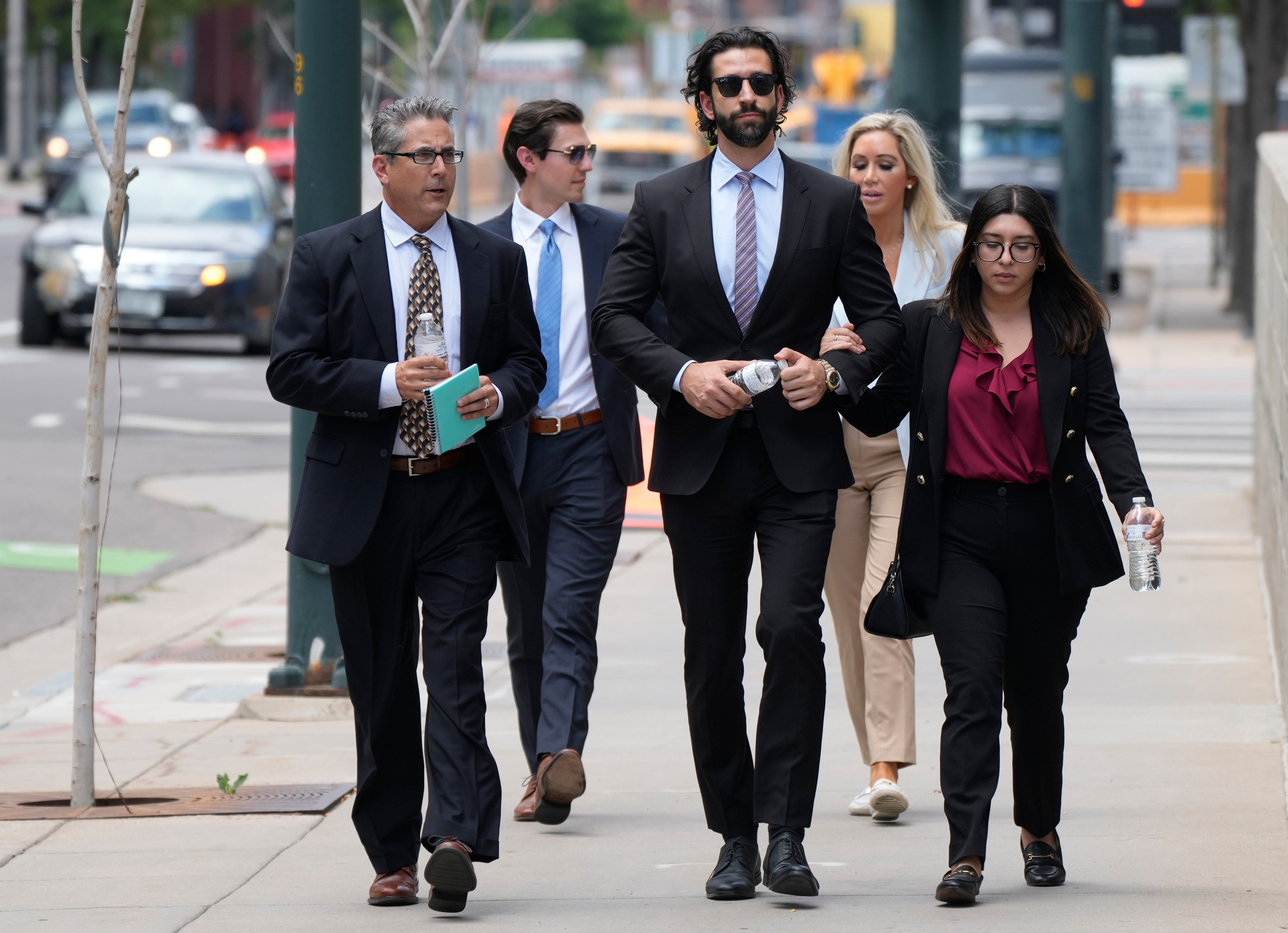 Defense attorneys for Pittsburgh dentist Lawrence "Larry" Rudolph head into federal courthouse with the dentist's children for the afternoon session of the trial, Wednesday, 13 July 2022, in Denver