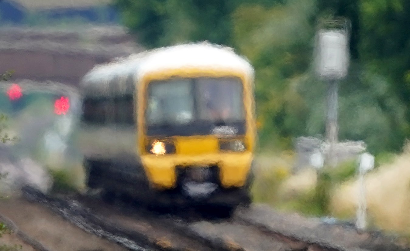 A train passes through heat haze on a railway line near Ashford in Kent