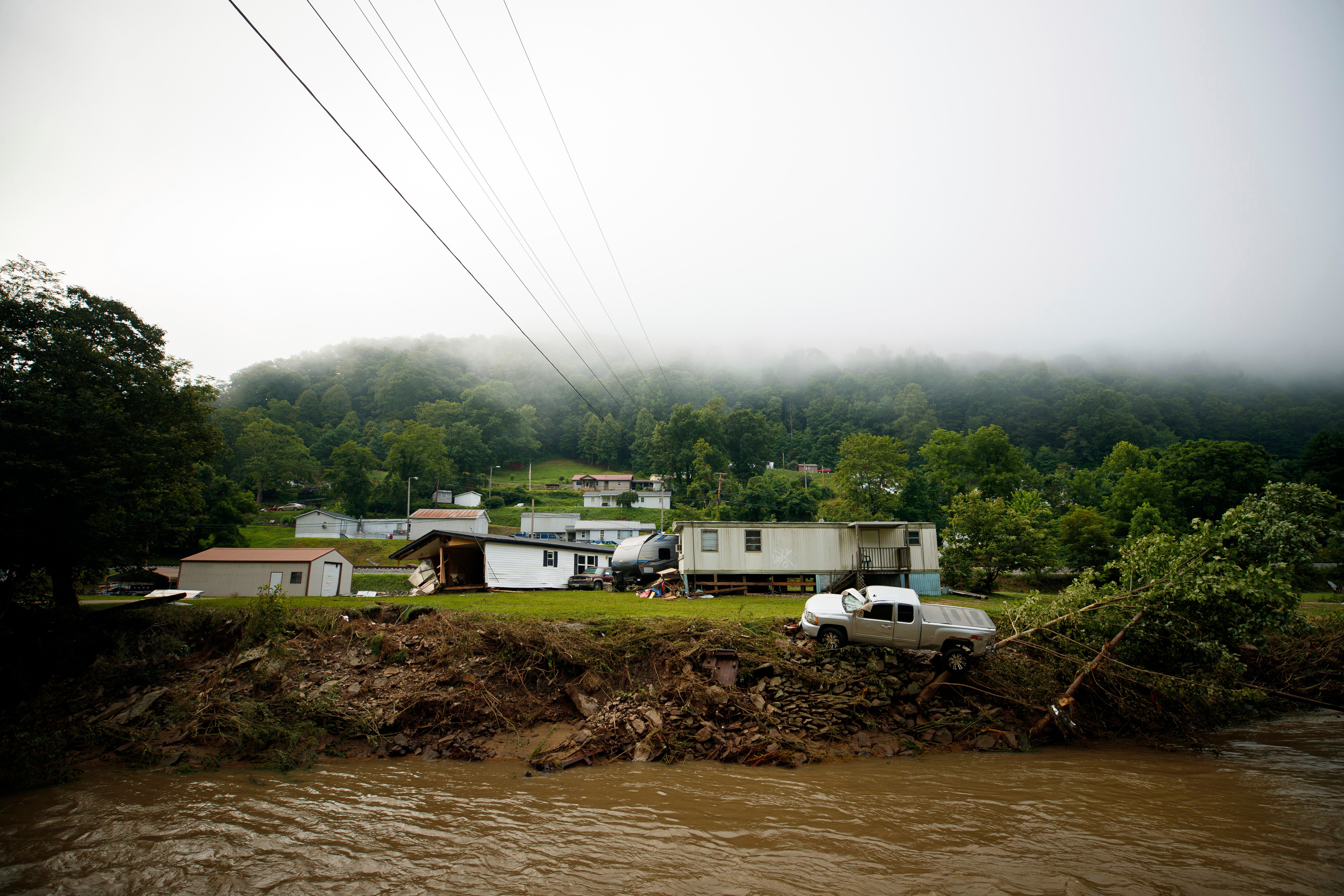 A truck teeters near the river after flooding washed through part of rural Appalachian Virginia