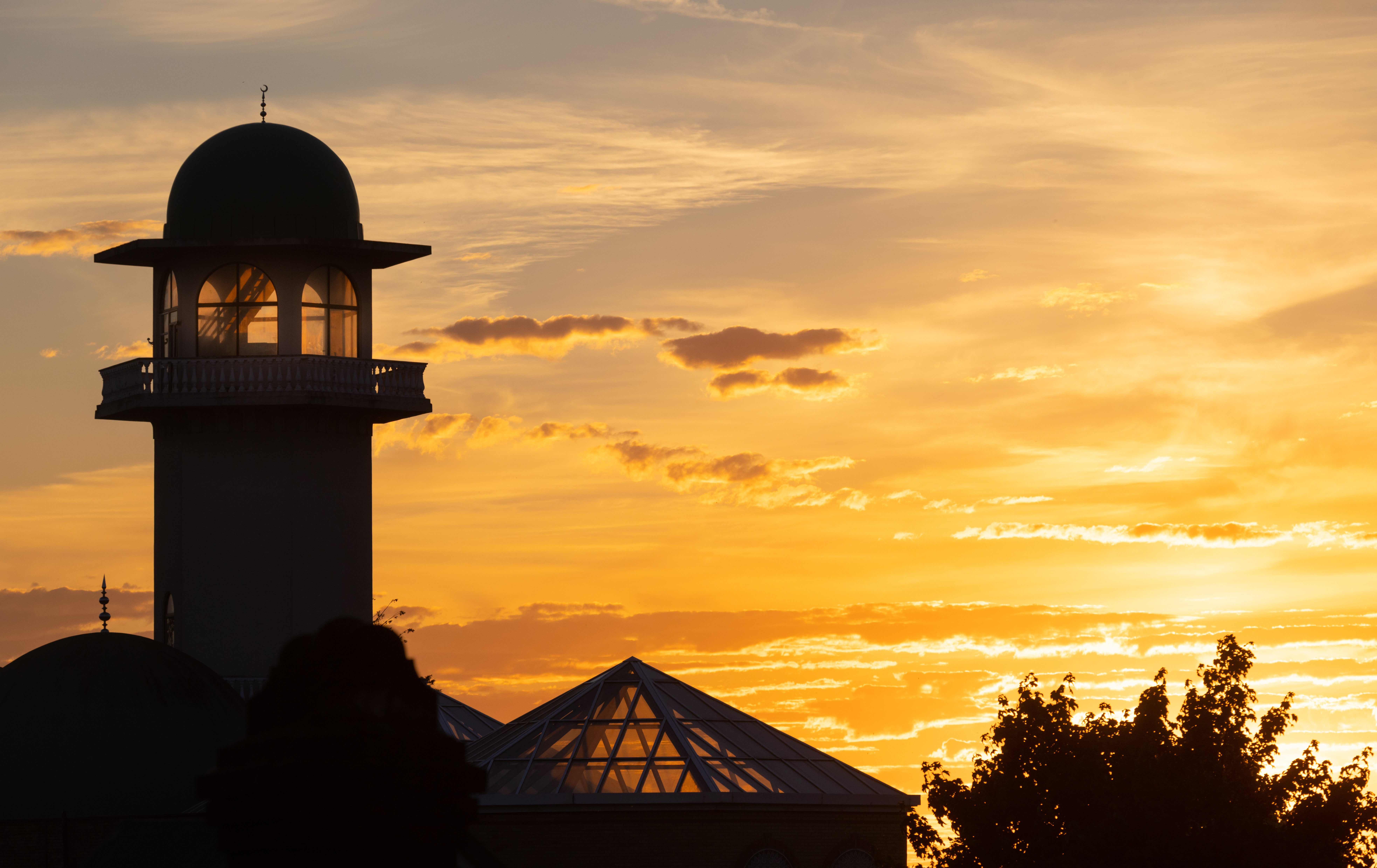 The sun sets over the Central Mosque of Brent, north London. Picture date: Sunday July 10, 2022.