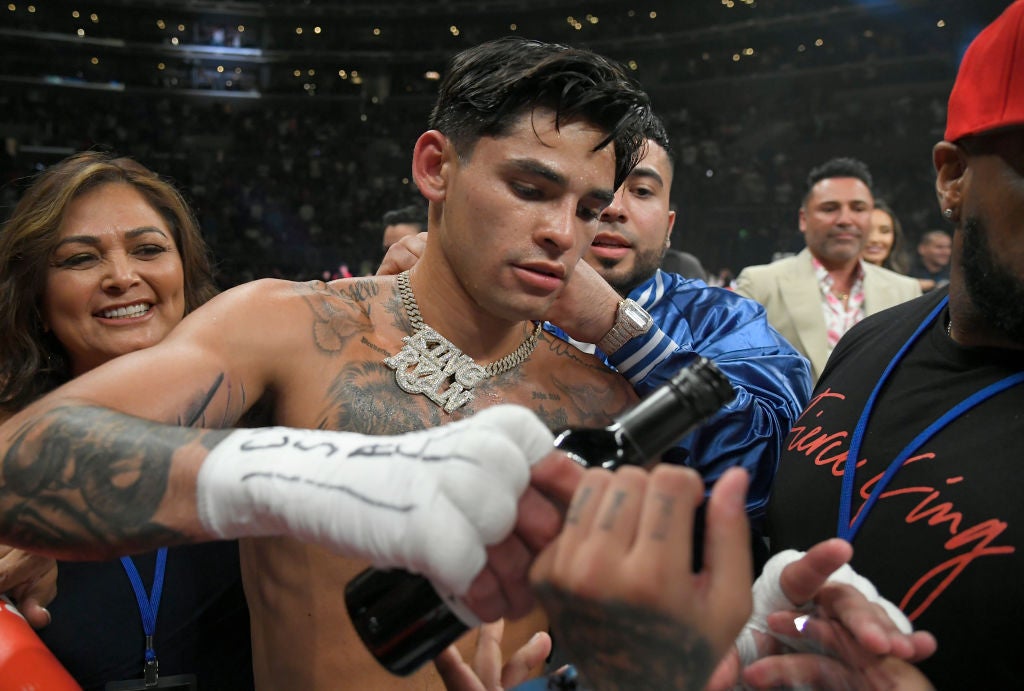 Garcia celebrated by opening a bottle of red wine in the ring