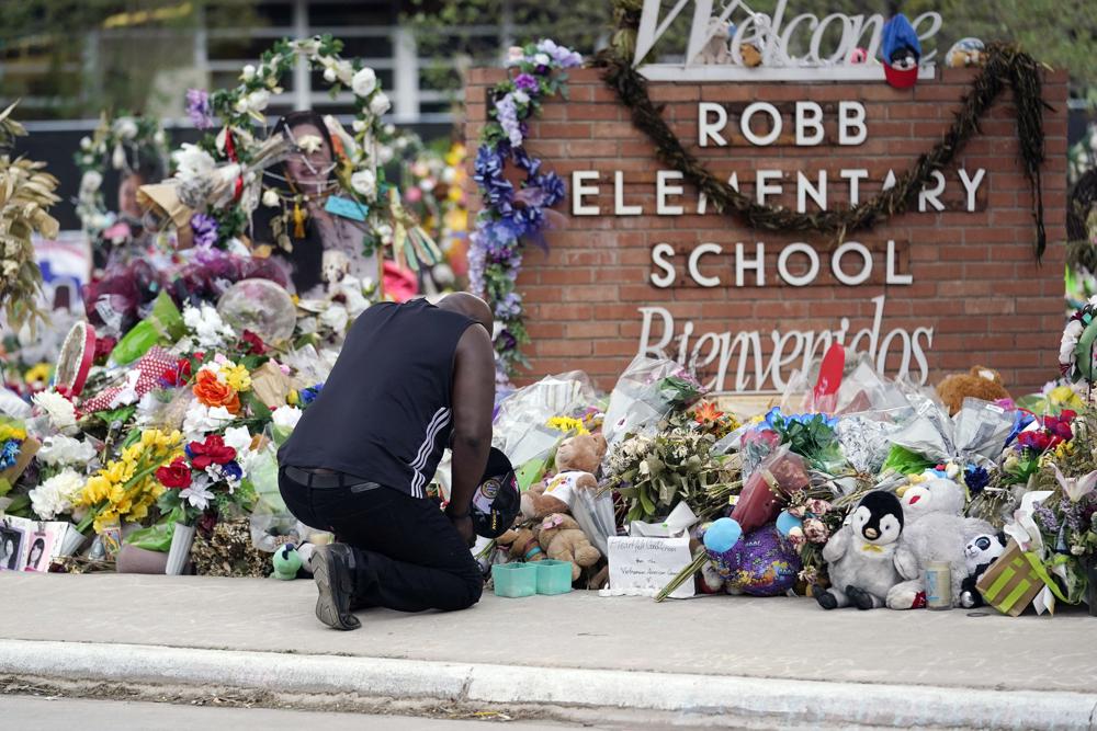 A mourner pays their respects outside Robb Elementary School